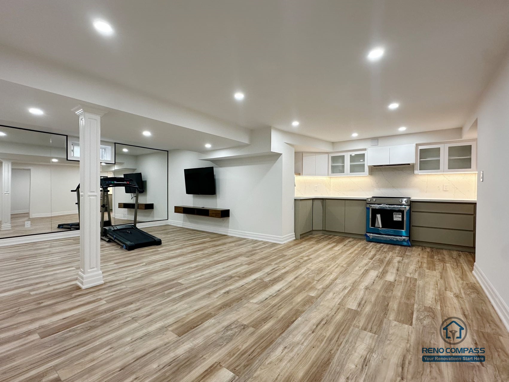 This image presents a completed open-concept basement renovation in Pickering, highlighting the overall spatial layout and flow between the kitchen, living area, and adjacent rooms. The design emphasizes flexibility and usability, with consistent flooring, recessed ceiling lighting, and clear circulation throughout the space. The kitchen is seamlessly integrated into the open layout, allowing the basement to function as an extension of the main living area. Neutral finishes and balanced proportions contribute to a bright, cohesive environment suitable for everyday living, entertainment, or multi-purpose use.
Location: Pickering · Toronto Contractor: Reno Compass