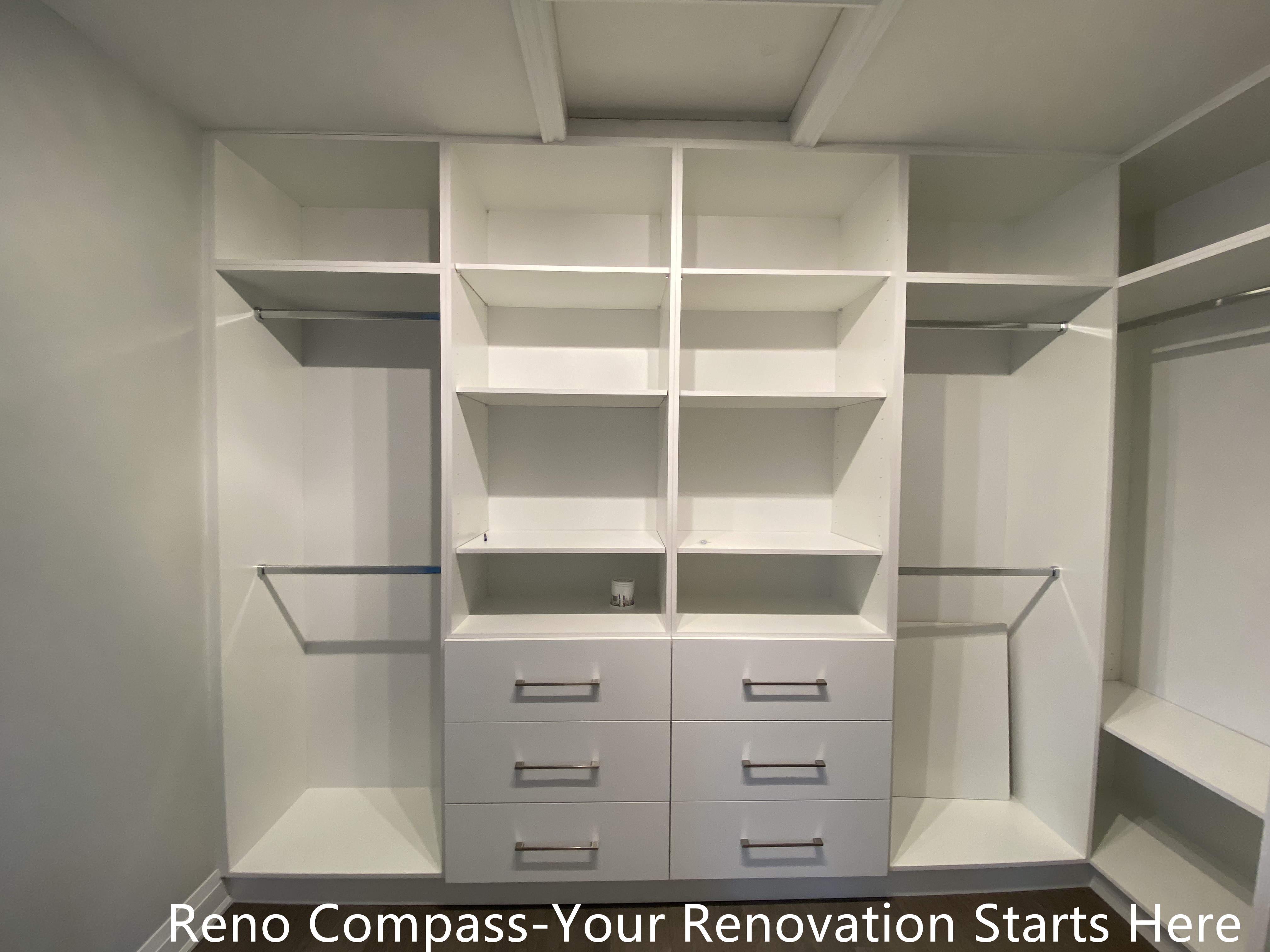 Custom walk-in closet featured in an Oakville interior renovation, showcasing built-in shelving, hanging rods, and integrated drawer storage for optimal organization. The clean white cabinetry and functional layout provide a modern storage solution designed and completed by a professional Toronto renovation company.
