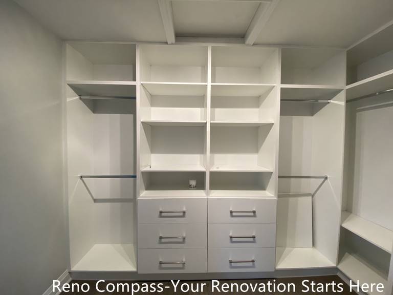 Custom walk-in closet featured in an Oakville interior renovation, showcasing built-in shelving, hanging rods, and integrated drawer storage for optimal organization. The clean white cabinetry and functional layout provide a modern storage solution designed and completed by a professional Toronto renovation company.