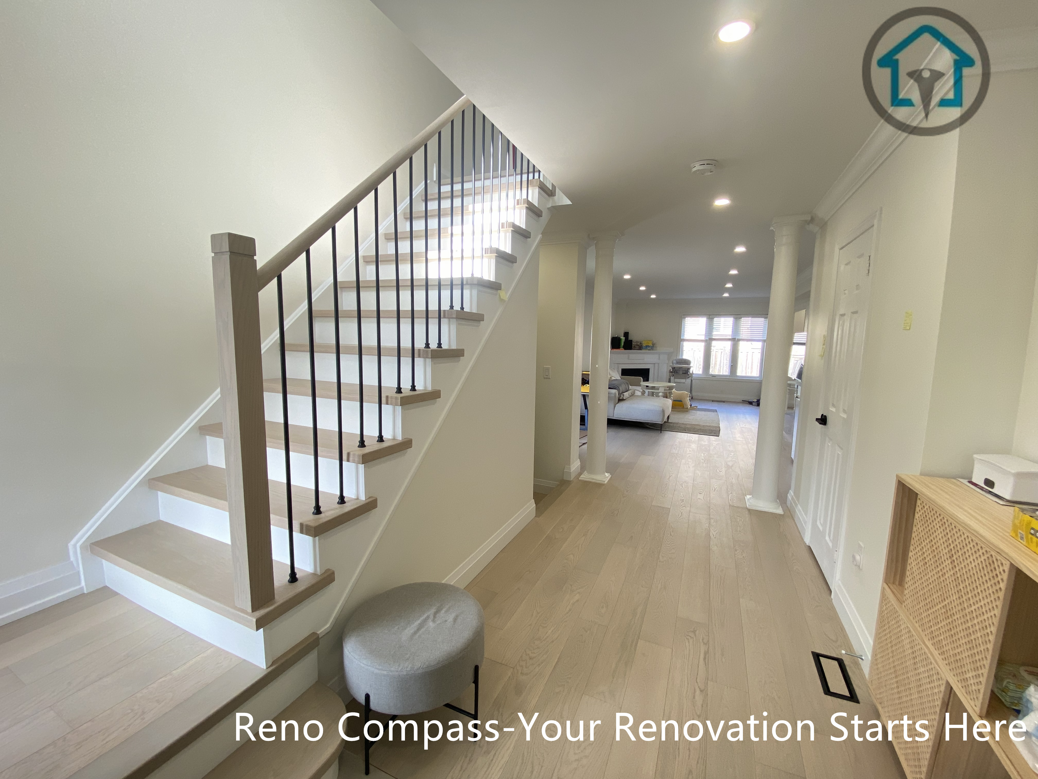 Modern flooring and staircase renovation in Markham featuring light oak hardwood floors, white riser stairs, and black iron balusters. The open staircase design enhances natural light flow and creates a clean, contemporary interior transition between floors. Completed by a professional Toronto renovation company with a focus on durability, safety, and timeless aesthetics.