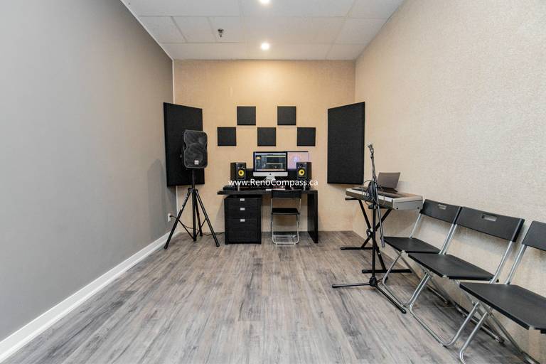 Professional interior renovation of a music production studio at The Singing School. This Richmond Hill project features custom-mounted acoustic foam panels, durable grey wood-grain laminate flooring, and recessed pot lighting. Expertly designed for both sound quality and commercial durability.