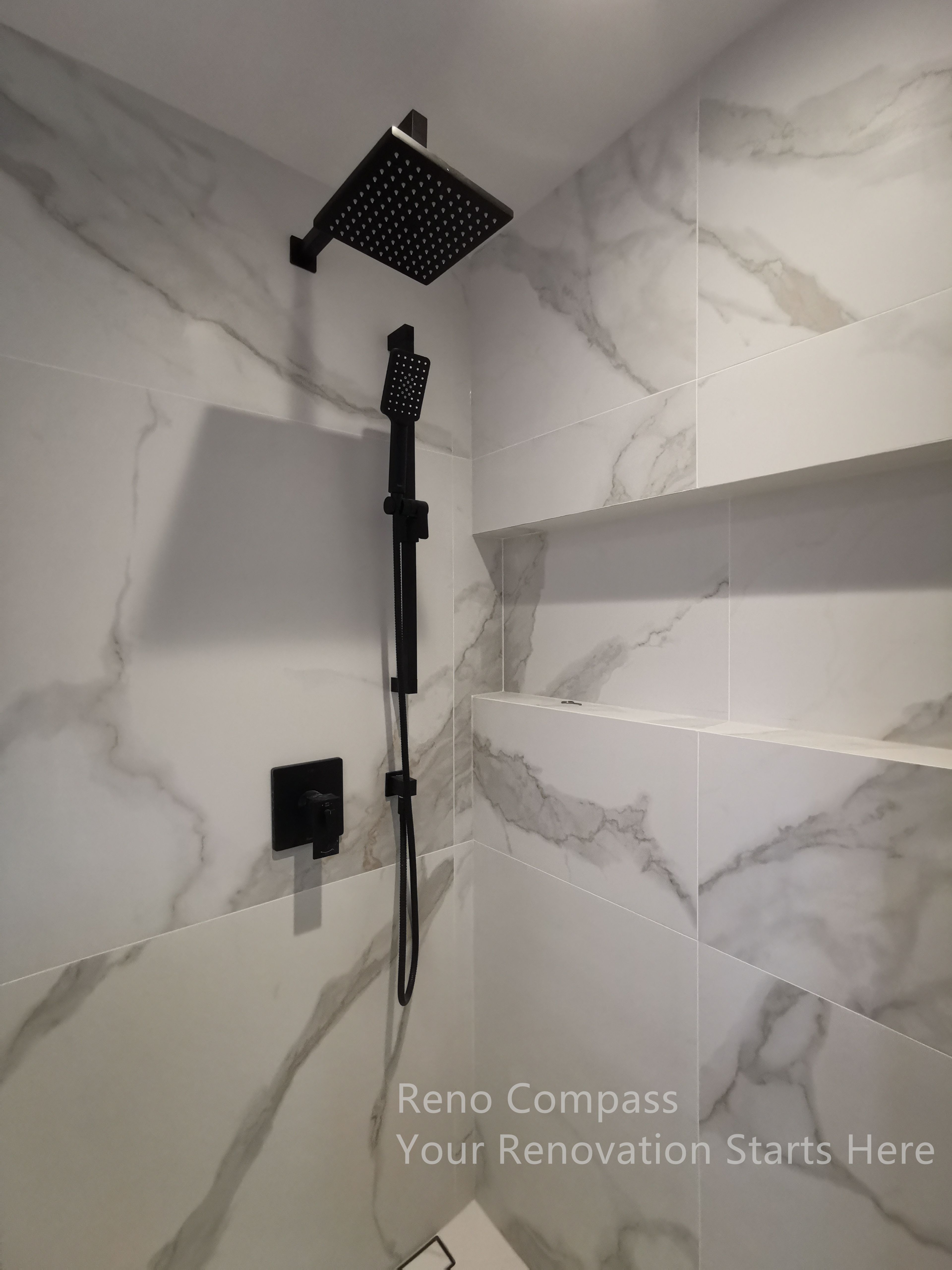 This image highlights a modern shower detail completed as part of a Markham interior renovation. Large-format marble-look wall tiles create a seamless and spacious visual effect, while built-in niche shelving provides practical storage without disrupting the clean lines. Matte black shower fixtures add strong contrast and a contemporary edge, balancing aesthetics with durability. The layout prioritizes ease of use, low maintenance, and long-term comfort, resulting in a bathroom space that feels refined, functional, and timeless.