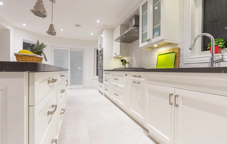 A wide‑angle view of the beautifully renovated kitchen from our Vaughan full house project. Featuring white shaker cabinets, quartz countertops, stainless steel appliances, and pendant lighting, this design blends elegance and practicality for a clean, timeless look.