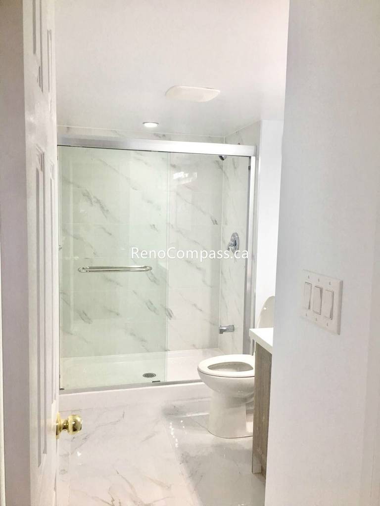 This Toronto basement renovation includes a newly built modern bathroom featuring marble-style wall and floor tiles, a sleek glass shower enclosure, and updated fixtures for a clean contemporary look. The bright design improves functionality and comfort while maximizing space in the finished basement. Completed by a professional Toronto renovation company, this bathroom renovation showcases quality craftsmanship, durable materials, and a stylish upgrade for everyday living.