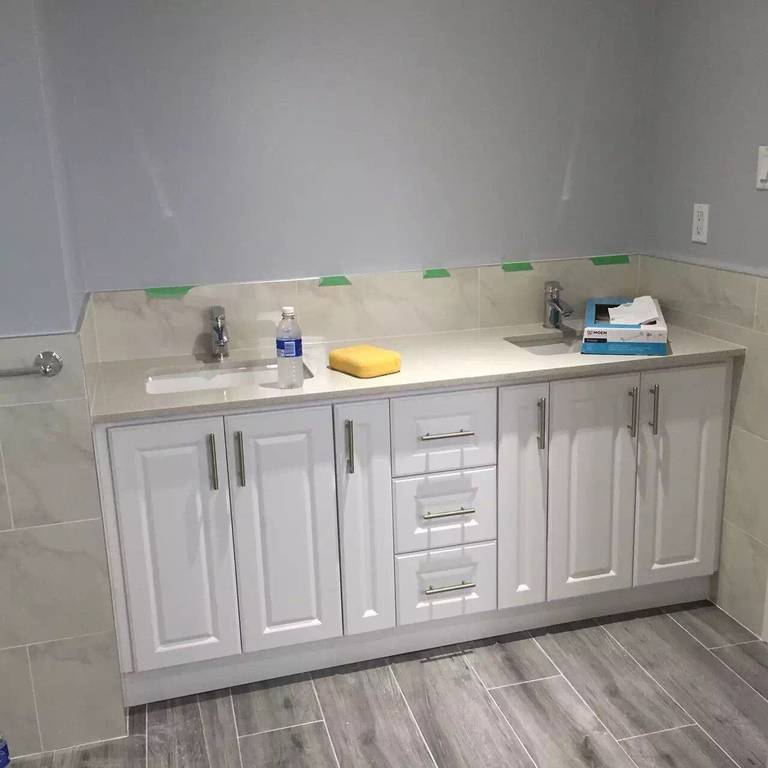 Sophisticated Toronto bathroom renovation featuring a white double-sink vanity, quartz countertop, brushed nickel fixtures, and porcelain tile flooring for a clean and modern look.