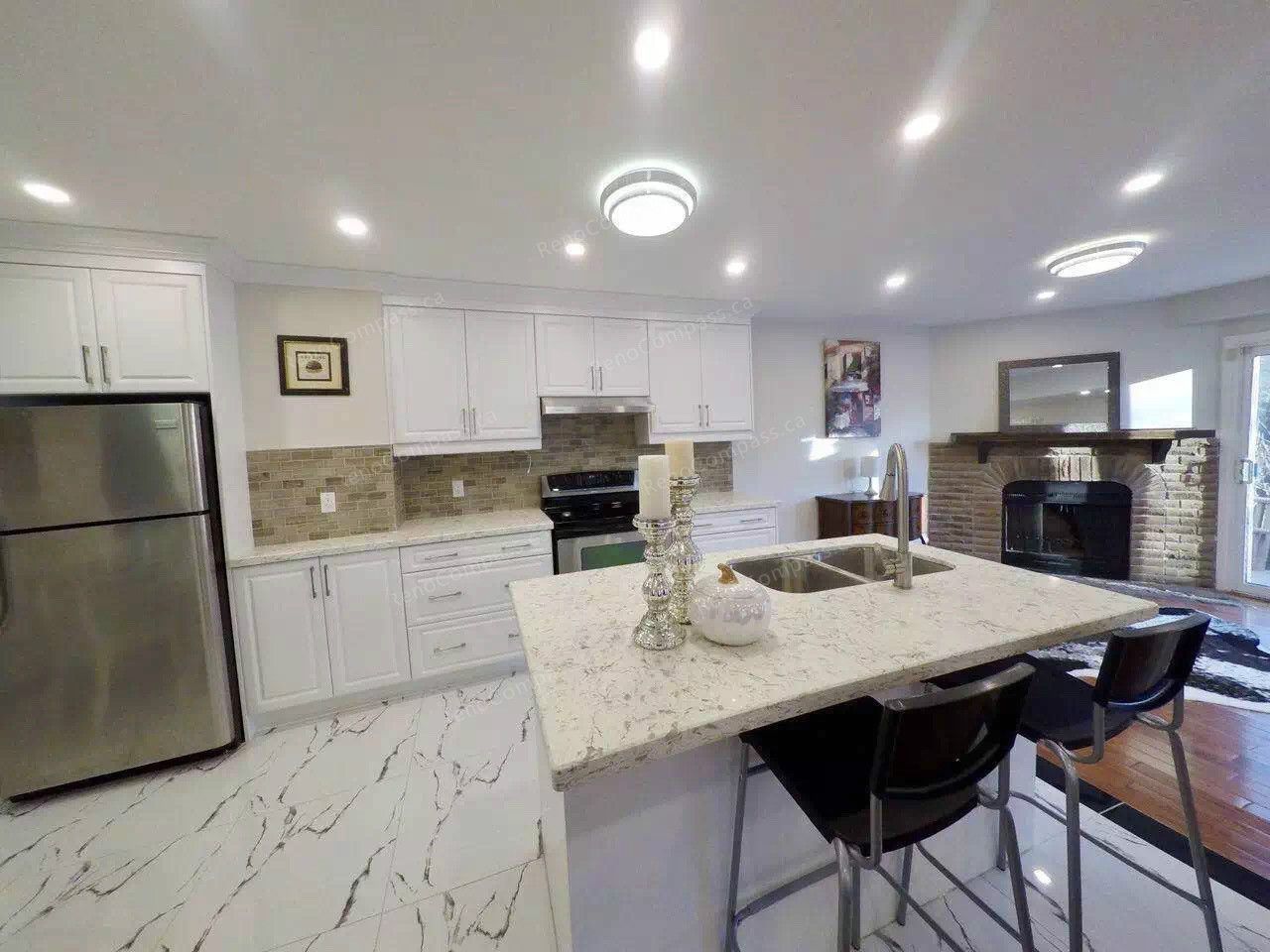 After renovation view of a modern open-concept kitchen in Scarborough featuring white cabinetry, quartz countertops, new tile flooring, upgraded lighting, and a functional island with double sink. Completed by a professional Toronto renovation company, this kitchen renovation enhances brightness, storage, and everyday usability while seamlessly connecting the dining and living areas.