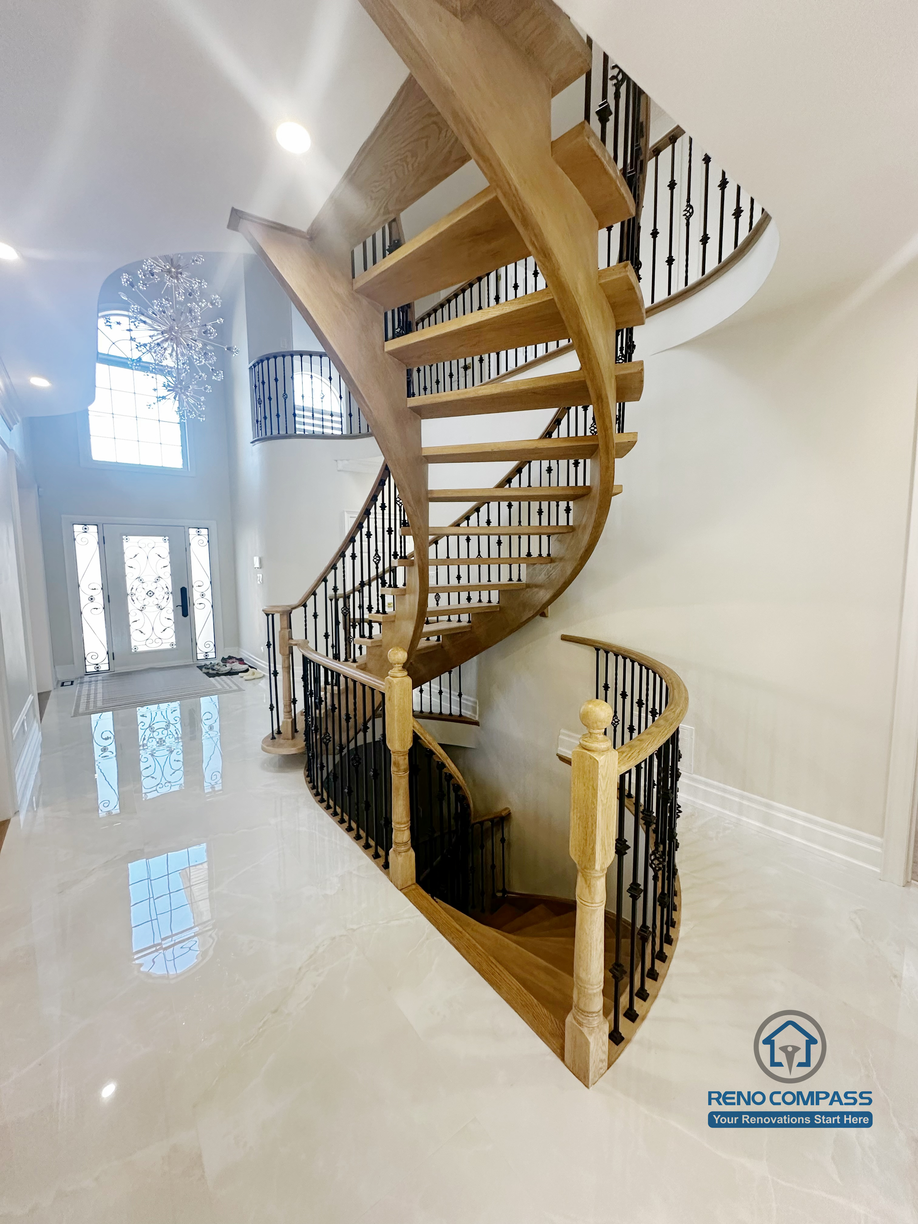 This image highlights a custom curved staircase featured in a North York flooring and stair renovation. The open-riser staircase is constructed with hardwood treads and paired with decorative iron railings, creating a visually light and sculptural form. The surrounding flooring and polished finishes enhance brightness and spatial flow throughout the main level. This design demonstrates precise craftsmanship and thoughtful integration of flooring and stair elements, contributing to a refined and cohesive interior layout for North York homes.