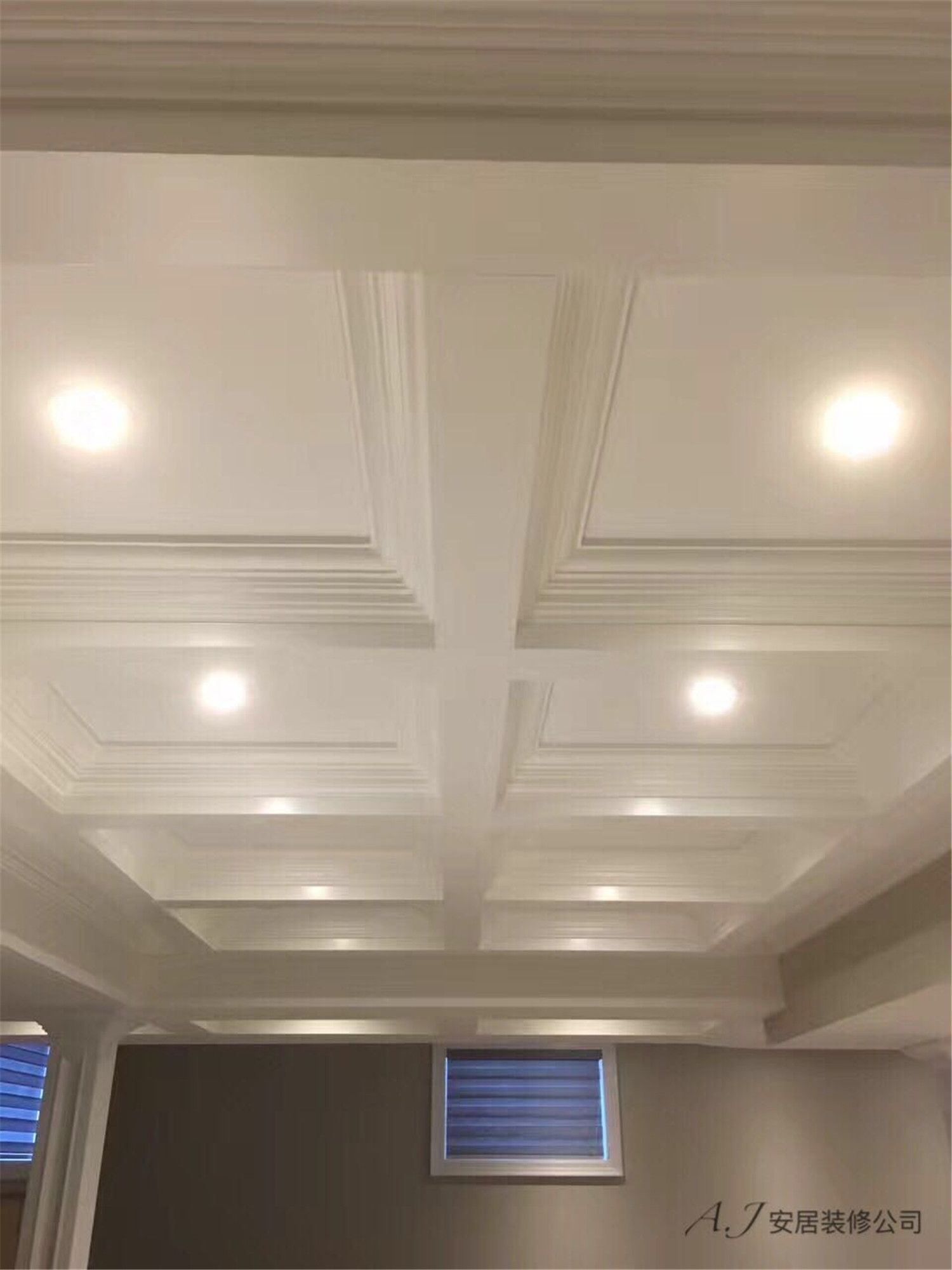 Architectural coffered ceiling above the staircase featuring recessed LED lighting and decorative trim detailing. This Toronto interior renovation enhances the vertical space with elegant ceiling craftsmanship and balanced lighting by a professional Toronto renovation company.
