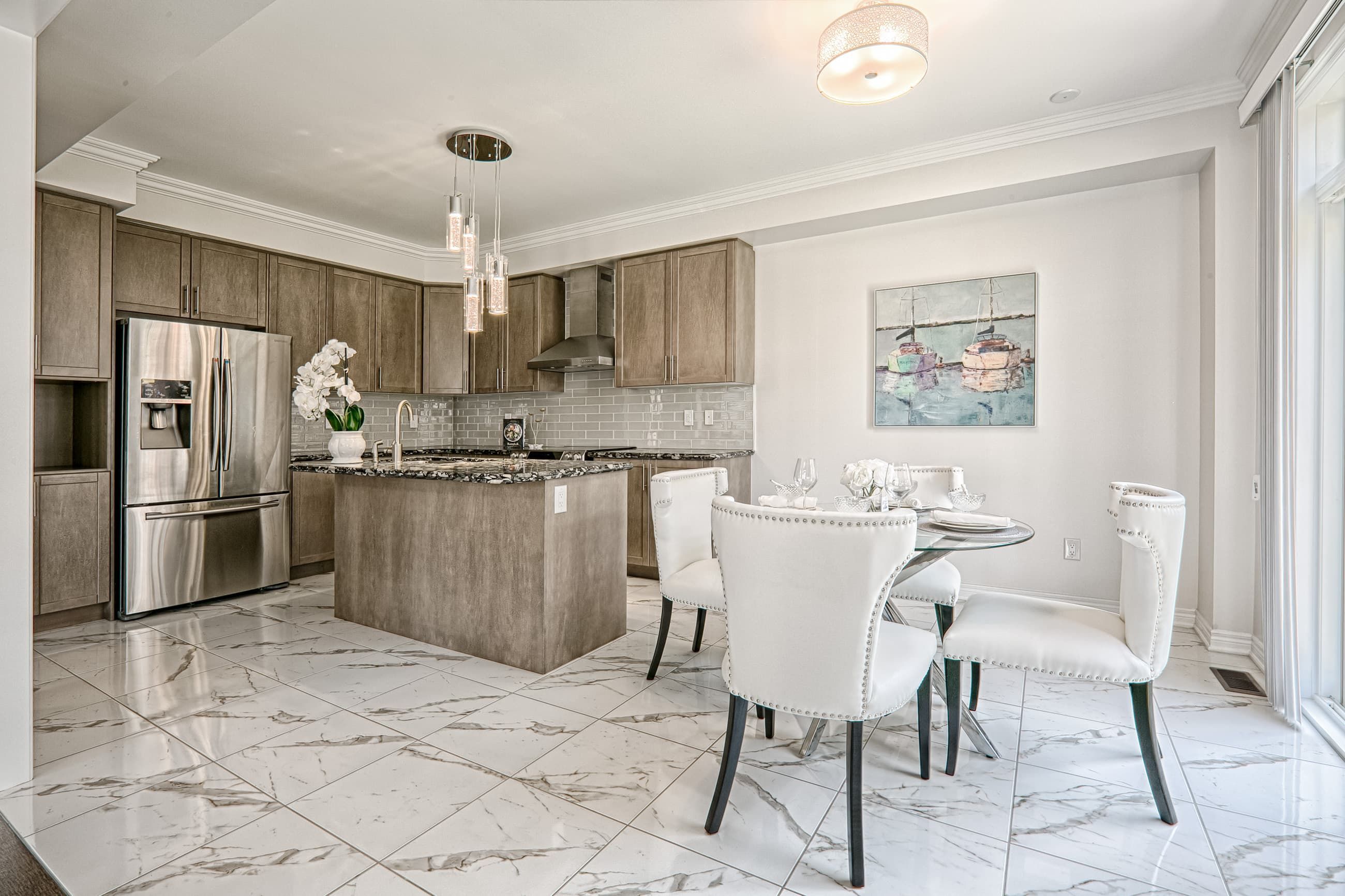 This Toronto modern luxury kitchen renovation features an open-concept layout with custom wood cabinetry, a large center island, and premium marble-style flooring. The space is enhanced by stainless steel appliances, modern pendant lighting, and a bright dining area that creates a functional and elegant family hub. Completed by a professional Toronto renovation company, this project highlights high-end craftsmanship, contemporary design, and practical living solutions tailored for modern homes.