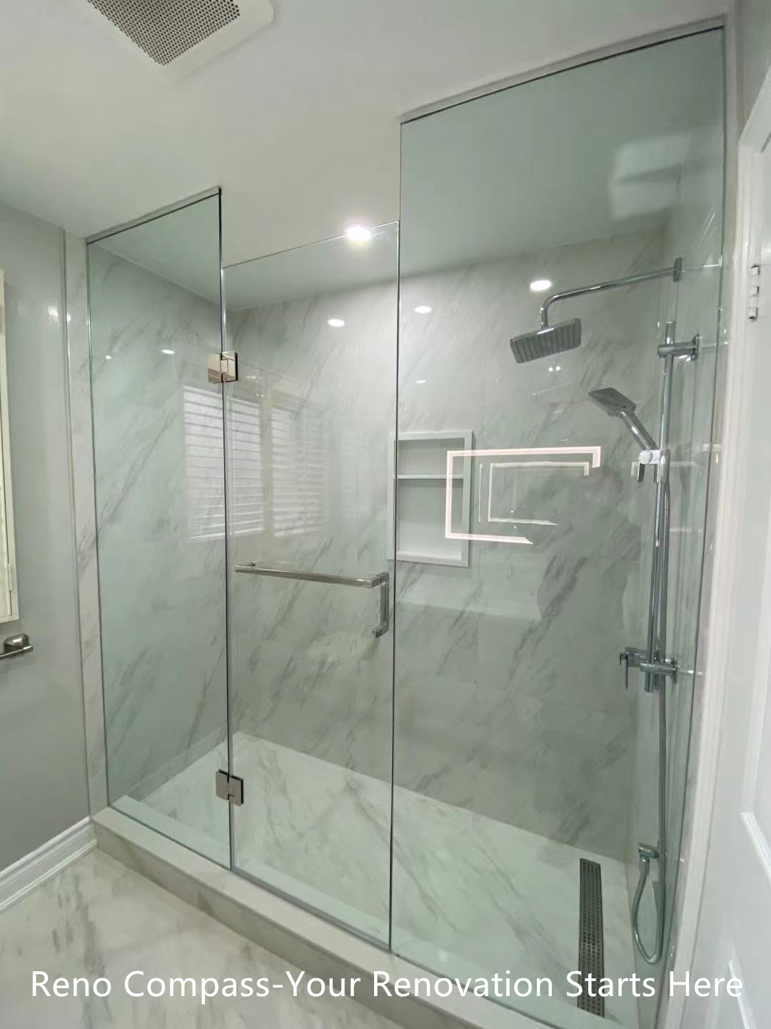 This Oakville interior renovation features a modern walk-in shower designed with frameless glass panels and full-height marble-look porcelain tiles. The clean glass enclosure enhances visual openness while allowing natural and artificial light to flow through the space. A rain shower system, wall-mounted hand shower, and built-in niche provide both comfort and functionality. The minimalist layout and neutral stone tones create a calm, spa-inspired bathroom environment that is durable, easy to maintain, and ideal for long-term residential use. This project reflects the precision detailing and modern design standards expected from a professional Toronto renovation company.