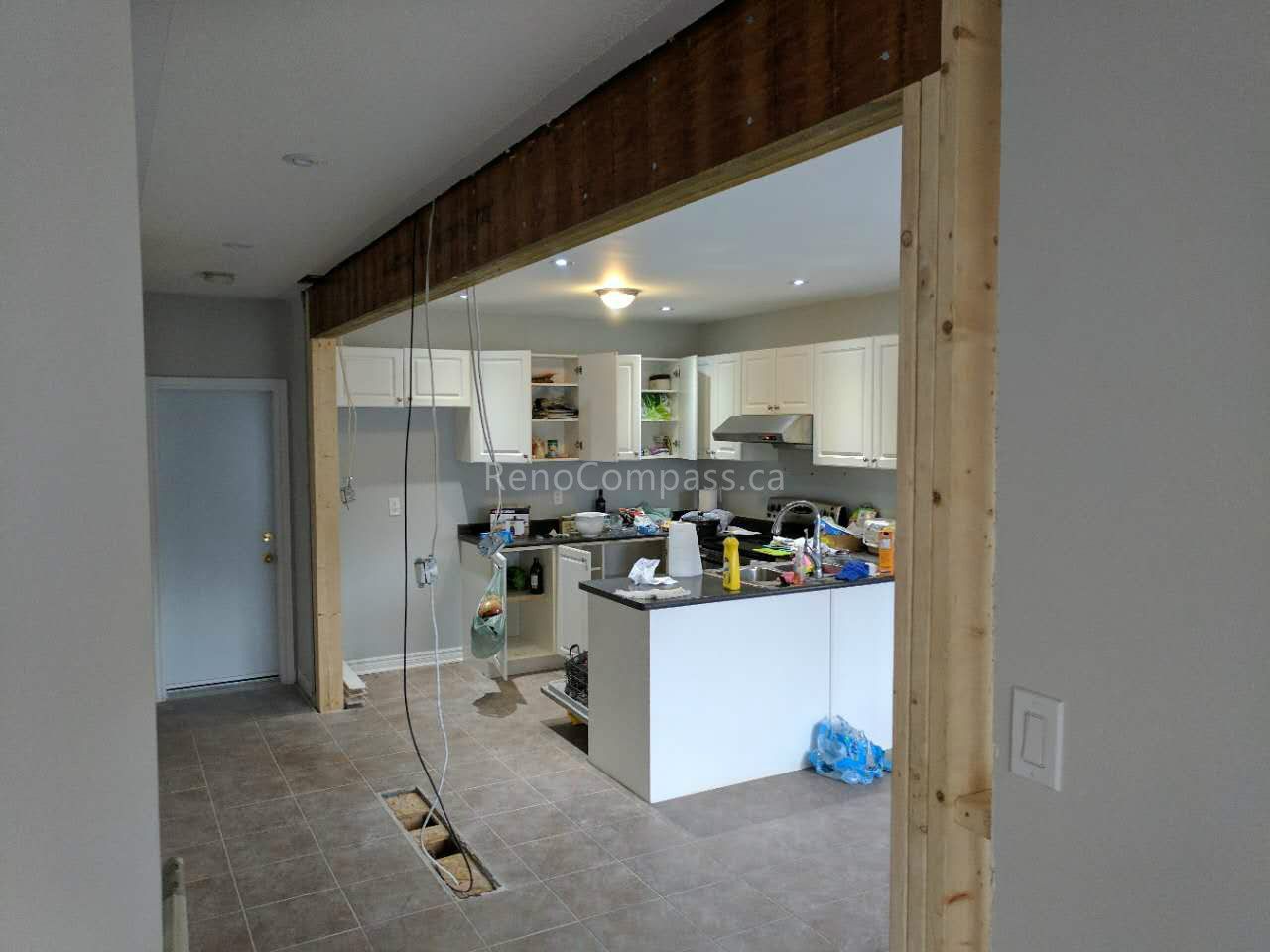 This Vaughan kitchen renovation showcases the remodeling process during construction, including structural opening expansion and layout reconfiguration to create a more open-concept kitchen. Reno Compass Inc. redesigned the space to improve flow, lighting, and functionality, preparing for new cabinetry, countertops, and modern finishes. Professional demolition and framing work ensure a strong foundation for a stylish and efficient kitchen transformation.