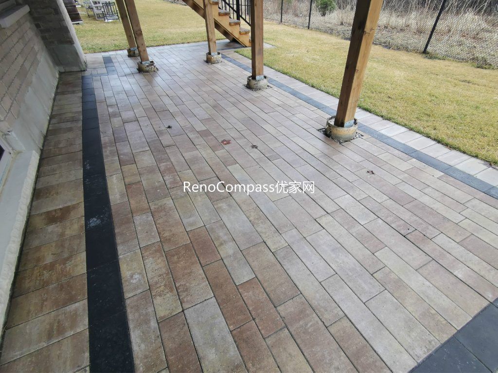 Professional interlocking patio installation in Aurora featuring durable stone pavers and clean border detailing beneath an elevated deck. This custom outdoor renovation improves drainage, usability, and backyard aesthetics while creating a functional covered patio space for all-season outdoor living.