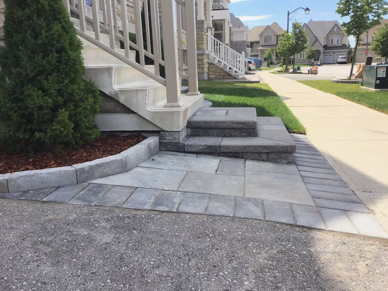 This Markham landscaping renovation highlights a professionally installed interlocking stone walkway and multi-level front entrance steps. The combination of clean lines and durable materials enhances both accessibility and curb appeal, creating a welcoming and long-lasting exterior upgrade.