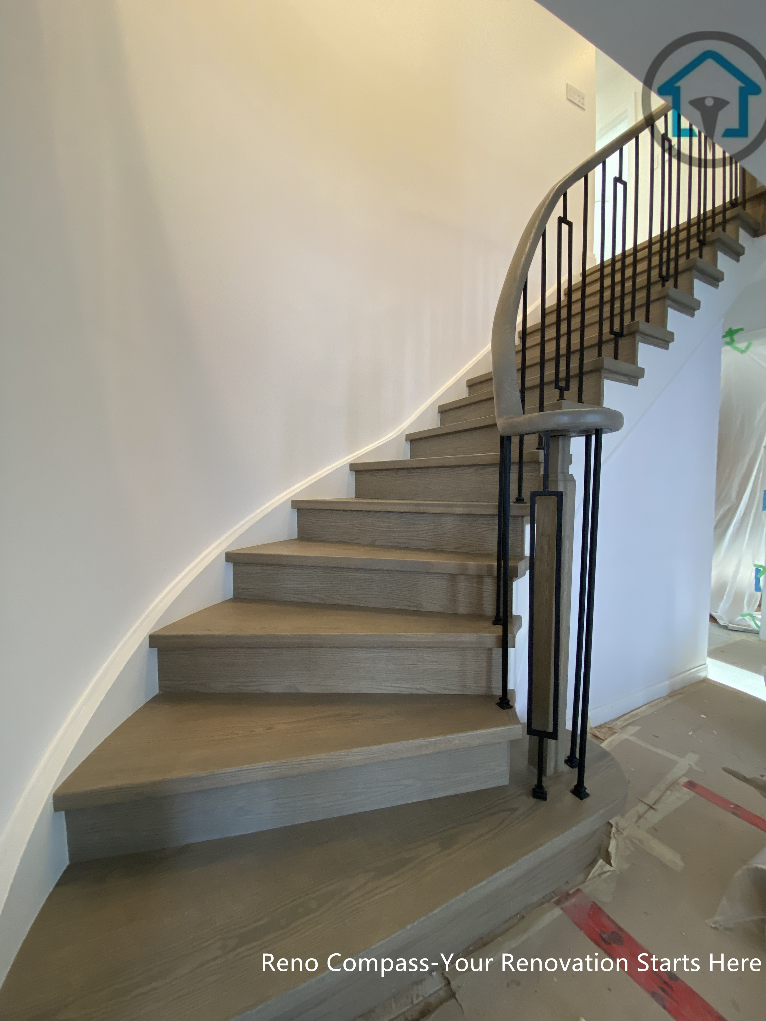 A close-up view of the staircase renovation in Markham, showcasing a modern black metal railing installed by Toronto Renovation Company Reno Compass Inc. The minimalist railing design adds structure and safety while maintaining an open and contemporary aesthetic.