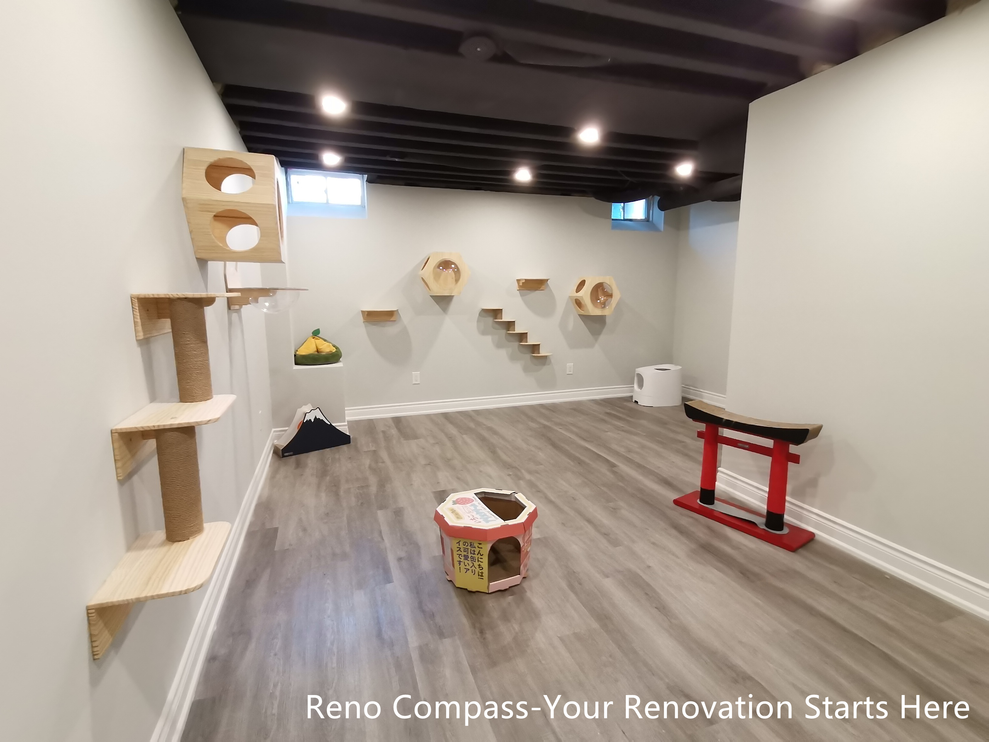 This Vaughan basement renovation features a dedicated cat activity wall integrated into an industrial-style interior with a sprayed black open ceiling and recessed lighting. Custom wall-mounted platforms and climbing elements are arranged with clear spacing and symmetry, allowing pets to move freely while preserving a clean and organized visual layout. Durable flooring and neutral wall finishes provide a practical foundation for daily use. Designed and completed by Reno Compass, this renovation demonstrates how pet-friendly features can be seamlessly incorporated into a modern, functional basement space.