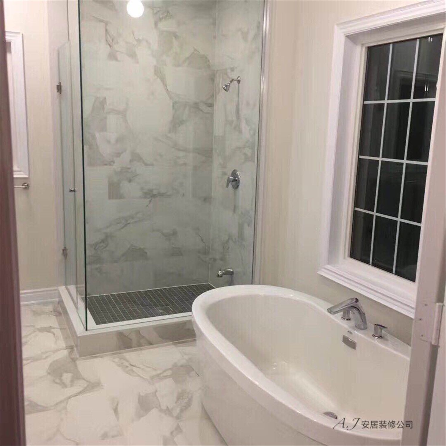 This Scarborough bathroom renovation features a modern spa-inspired layout with a freestanding bathtub and a frameless glass walk-in shower. Large-format marble-look tiles create a bright and elegant atmosphere, while the sleek chrome fixtures and minimalist design enhance the overall sense of luxury. The combination of natural light from the window, clean lines, and contemporary materials highlights a refined and functional bathroom upgrade in this Scarborough home.
