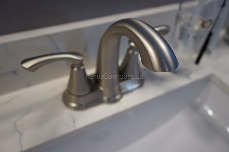 Close-up of a modern brushed nickel bathroom faucet installed on a marble countertop as part of a Markham bathroom renovation. The upgraded sink fixtures combine durability, functionality, and elegant design, adding a refined finishing touch to this clean and contemporary bathroom space.