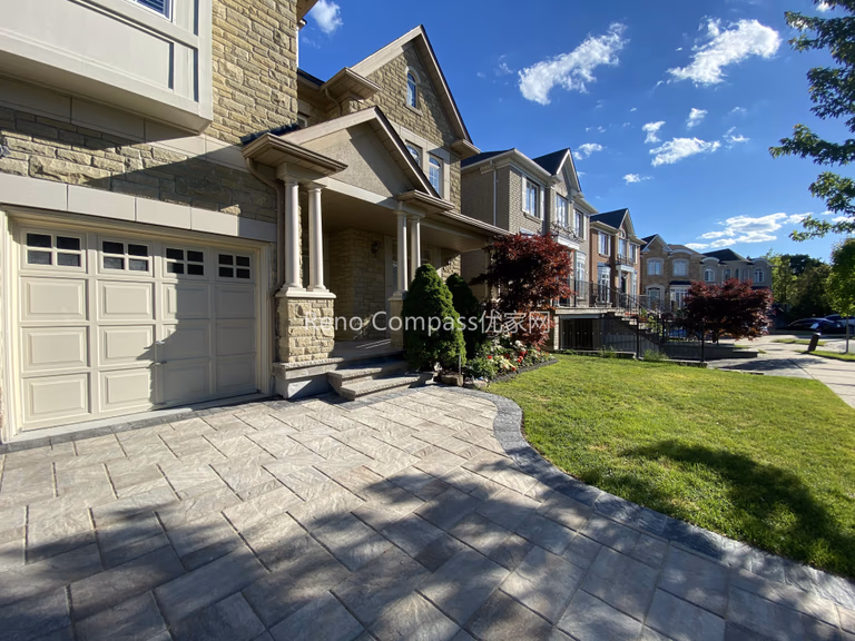 This image presents the completed exterior view of a North York driveway interlocking project featuring natural stone paving throughout the driveway, walkway, and front entrance area. The interlocking layout follows the home’s architectural lines, creating a smooth transition from the driveway to the front steps and surrounding landscape. Natural stone pavers enhance curb appeal while providing durability, proper drainage, and long-term performance for daily use. The finished result integrates seamlessly with the home’s façade and neighborhood streetscape. Completed by a Toronto interlocking and landscaping contractor, this project reflects a comprehensive approach to exterior hardscape design and craftsmanship.