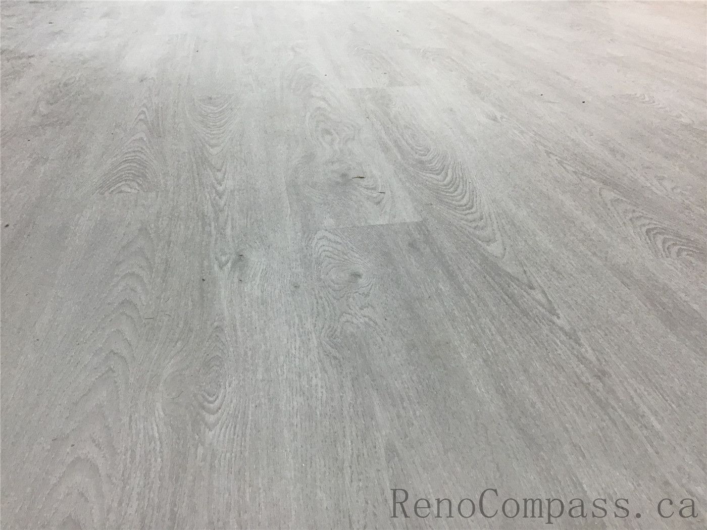 Close-up view of newly installed light grey vinyl flooring in this Pickering basement renovation project. The durable waterproof flooring features a modern wood-grain texture, creating a bright and contemporary foundation for the finished basement space. Installed by Reno Compass Inc., a professional Toronto Renovation Company specializing in basement upgrades and interior renovations.