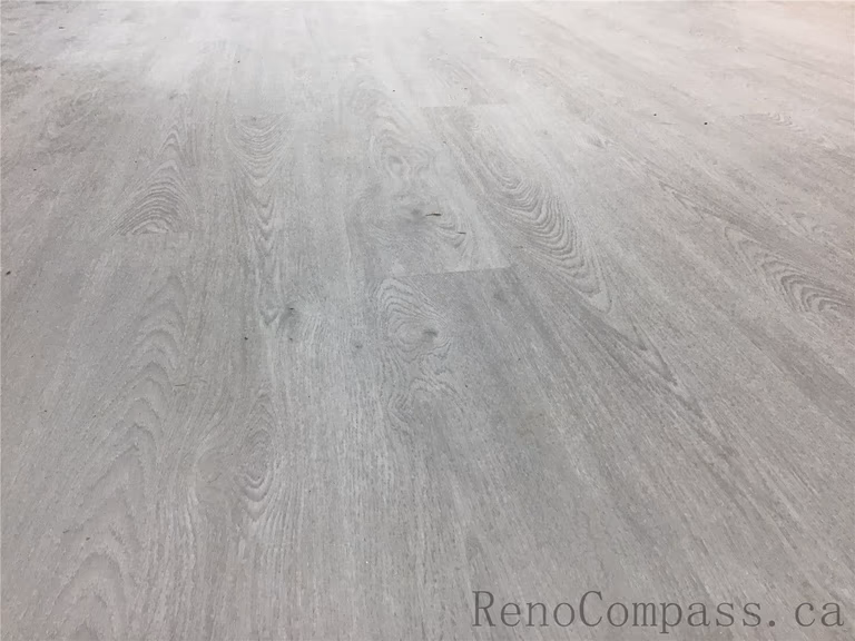 Close-up view of newly installed light grey vinyl flooring in this Pickering basement renovation project. The durable waterproof flooring features a modern wood-grain texture, creating a bright and contemporary foundation for the finished basement space. Installed by Reno Compass Inc., a professional Toronto Renovation Company specializing in basement upgrades and interior renovations.