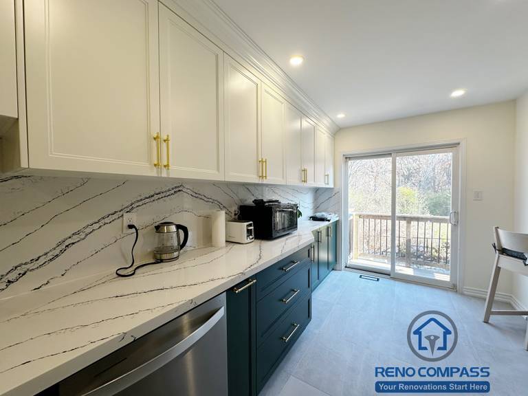 This Mississauga kitchen renovation features an extended preparation counter with quartz surfaces, custom cabinetry, and abundant natural light from the rear patio doors. The layout creates a bright, comfortable workspace that supports daily cooking, food prep, and casual dining connection.