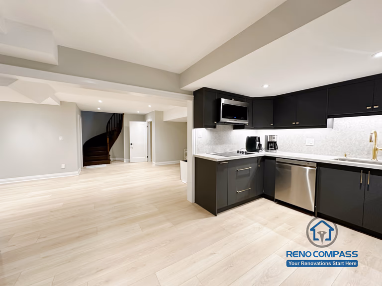Basement renovation in Richmond Hill featuring a modern kitchenette with matte black cabinetry, stainless steel appliances, quartz-style countertops, and efficient space planning for daily use.