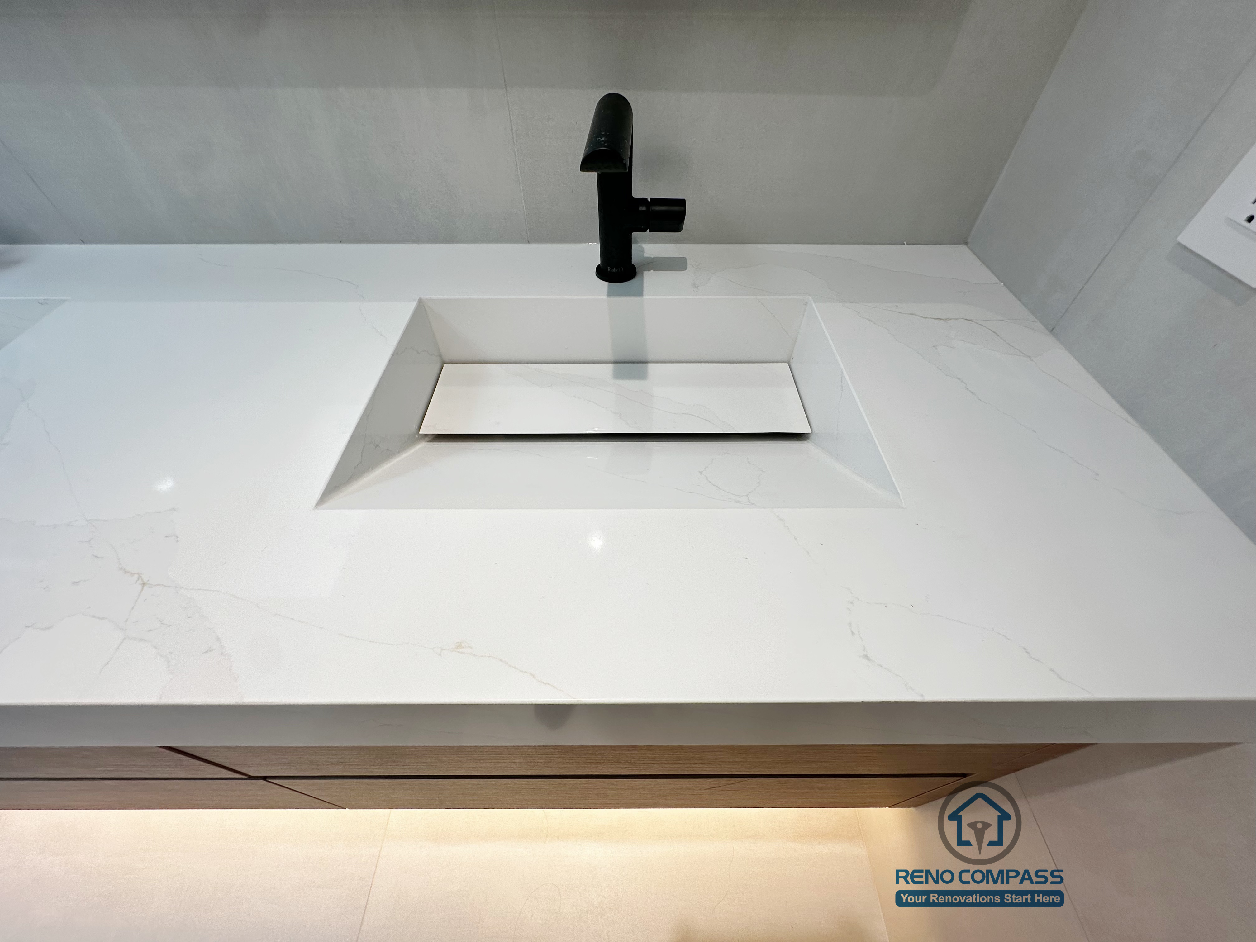 This Markham bathroom renovation highlights a minimalist integrated sink design paired with a matte black faucet and seamless quartz countertop.
The clean geometry and refined detailing emphasize durability, ease of maintenance, and modern elegance.