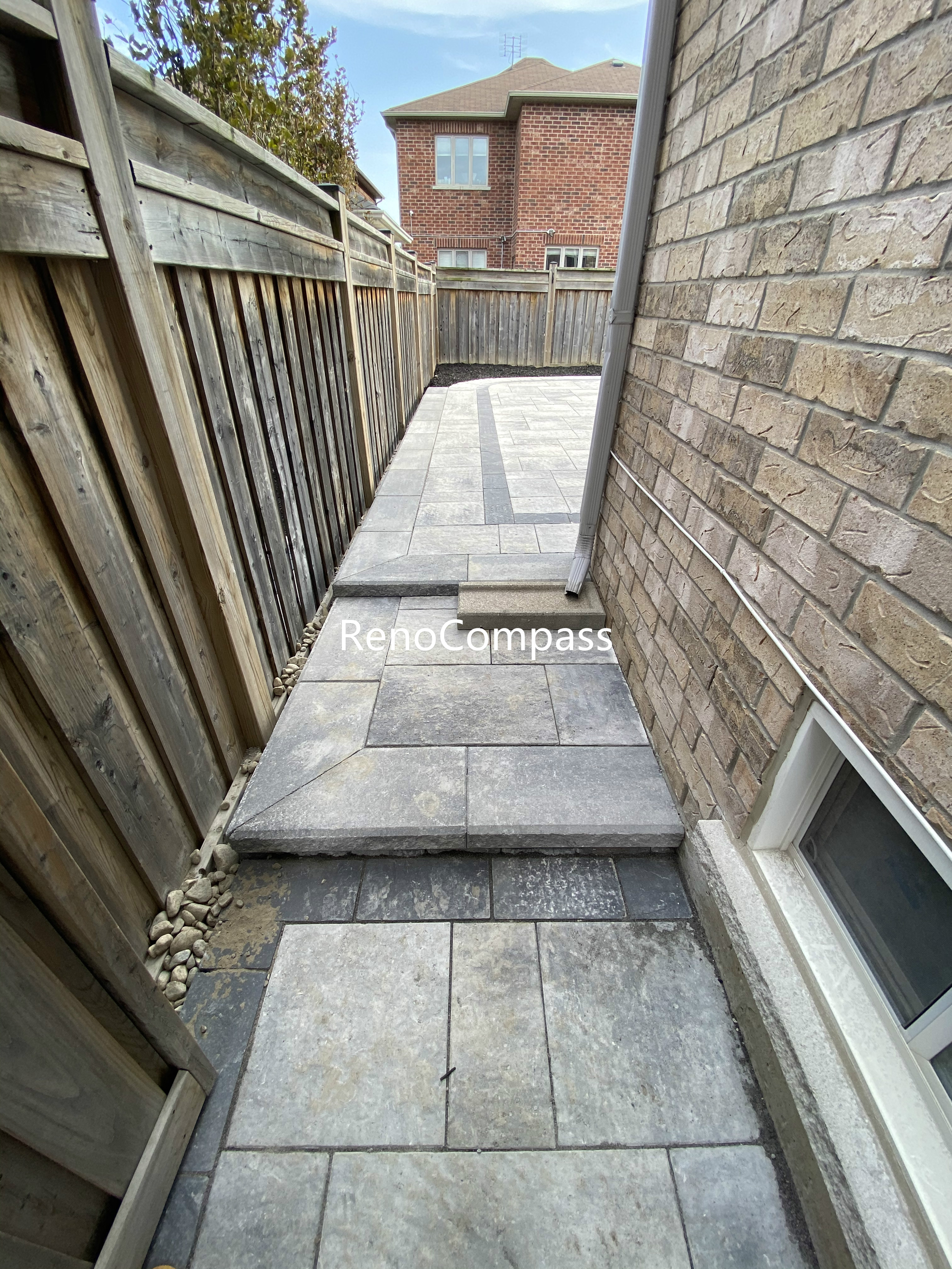 This Aurora side yard interlocking walkway features a clean and practical paver layout designed to improve accessibility and durability. Large-format concrete pavers are installed with precise spacing to ensure stability, proper drainage, and long-term performance. The neutral stone tones complement the home’s exterior while creating a smooth transition between the front and backyard areas. This professionally installed interlock walkway enhances both functionality and visual consistency, making it a reliable outdoor upgrade for residential properties in Aurora.