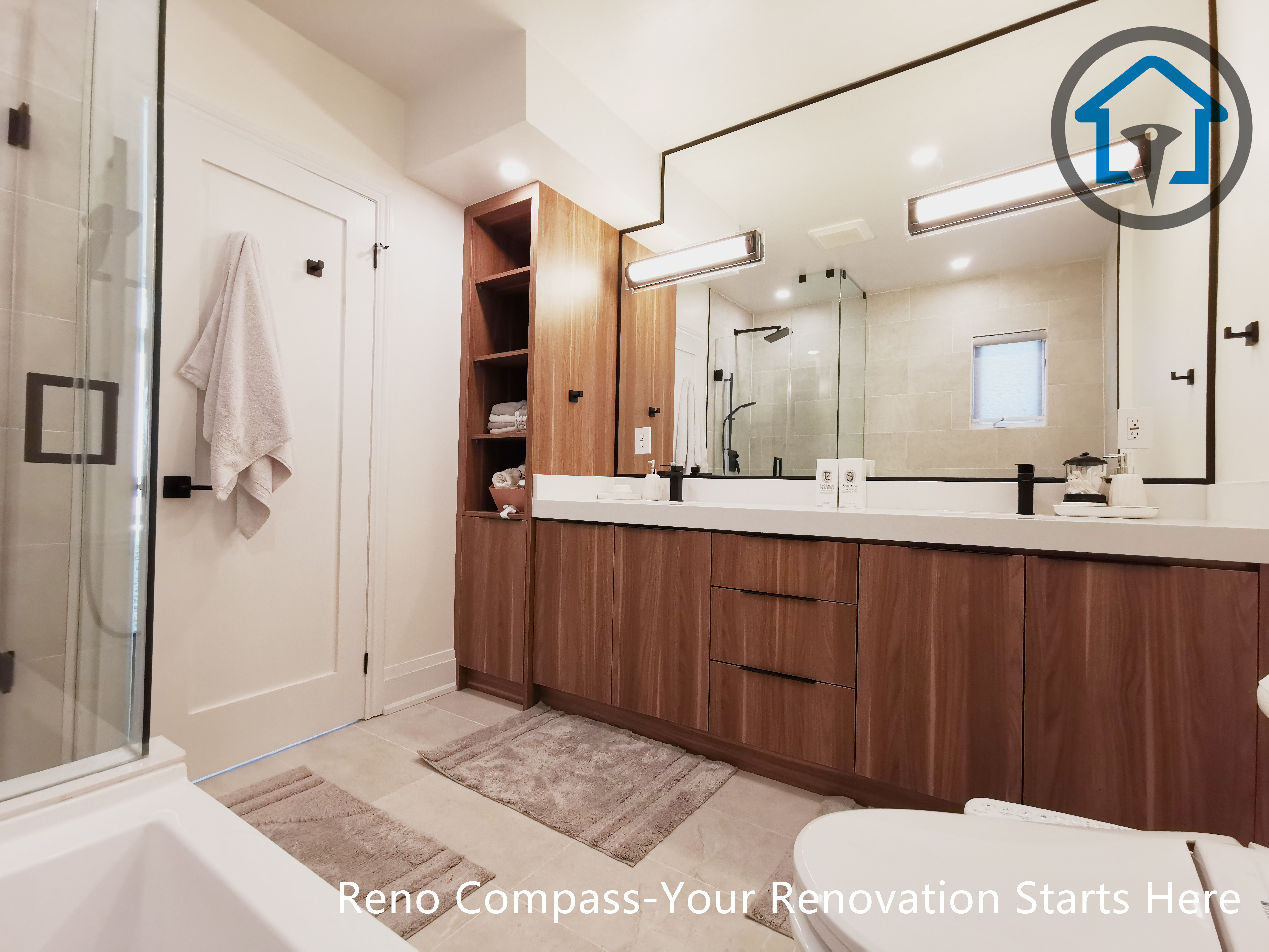 This North York bathroom renovation features a custom wood vanity with double sinks, integrated storage, and modern LED mirror lighting. The warm wood tones are balanced with clean white surfaces and matte black fixtures, creating a functional and refined bathroom space completed by a Toronto renovation company focused on craftsmanship and practical design.