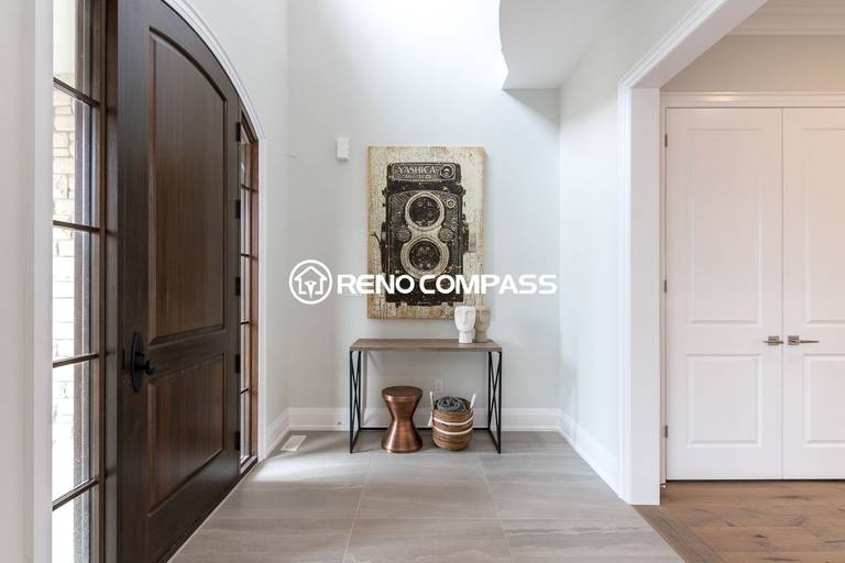 This image shows a bright and modern home entrance after a Newmarket flooring renovation project in Toronto. The homeowner selected engineered wood flooring, which provides the natural appearance and comfortable feel of solid hardwood while offering greater structural stability. Engineered wood floors are constructed with multiple layers of wood pressed together in a cross-grain structure, helping prevent expansion, cracking, and warping. This flooring upgrade enhances durability, improves moisture resistance, and creates a clean, elegant entry space for the home. Renovation completed by Reno Compass Inc., a Toronto renovation company specializing in flooring installation and interior upgrades.