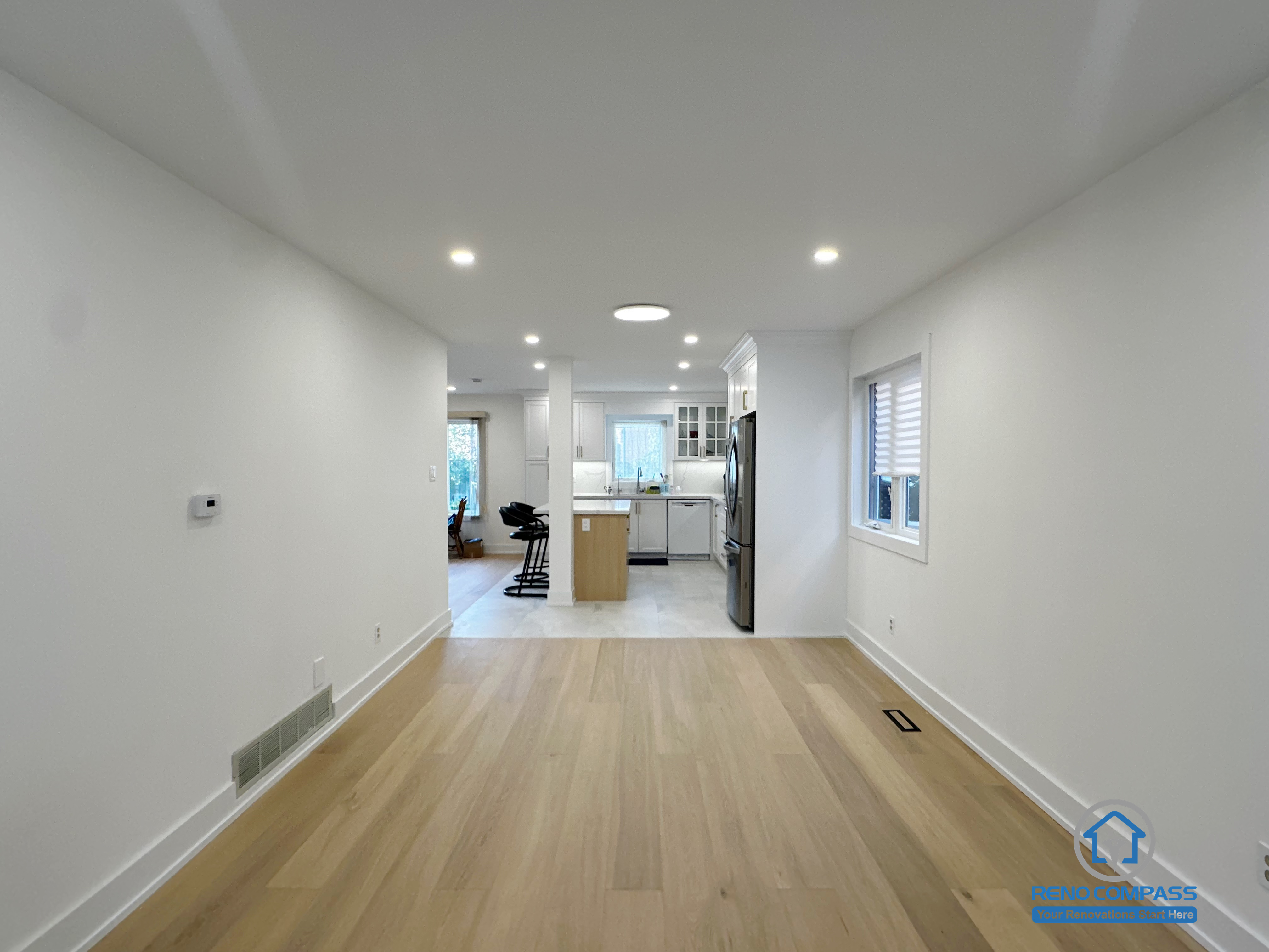This Richmond Hill interior renovation showcases an open-concept living space with seamless circulation leading toward the kitchen area. Natural hardwood flooring, recessed ceiling lights, and clean wall lines create a bright and continuous visual flow. The layout enhances spatial depth and everyday functionality, making the area suitable for living, dining, or family activities. Completed as part of a Toronto renovation project focused on openness, comfort, and long-term livability.