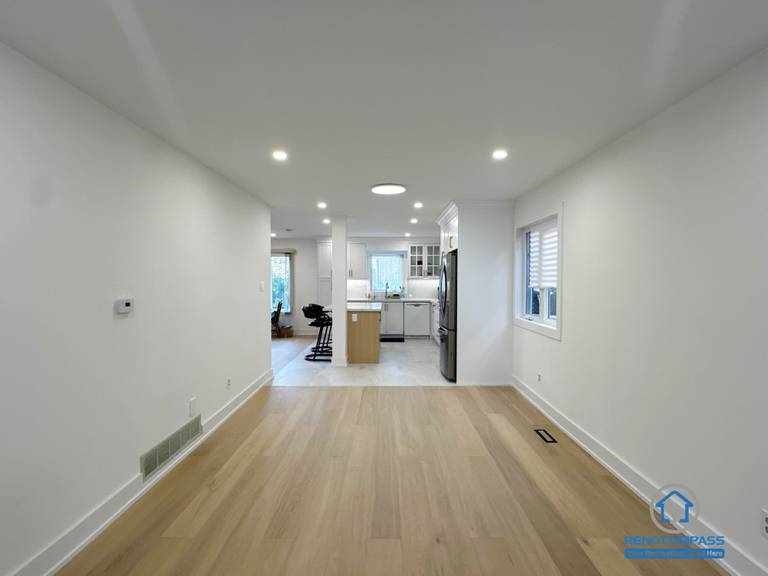 This Richmond Hill interior renovation showcases an open-concept living space with seamless circulation leading toward the kitchen area. Natural hardwood flooring, recessed ceiling lights, and clean wall lines create a bright and continuous visual flow. The layout enhances spatial depth and everyday functionality, making the area suitable for living, dining, or family activities. Completed as part of a Toronto renovation project focused on openness, comfort, and long-term livability.