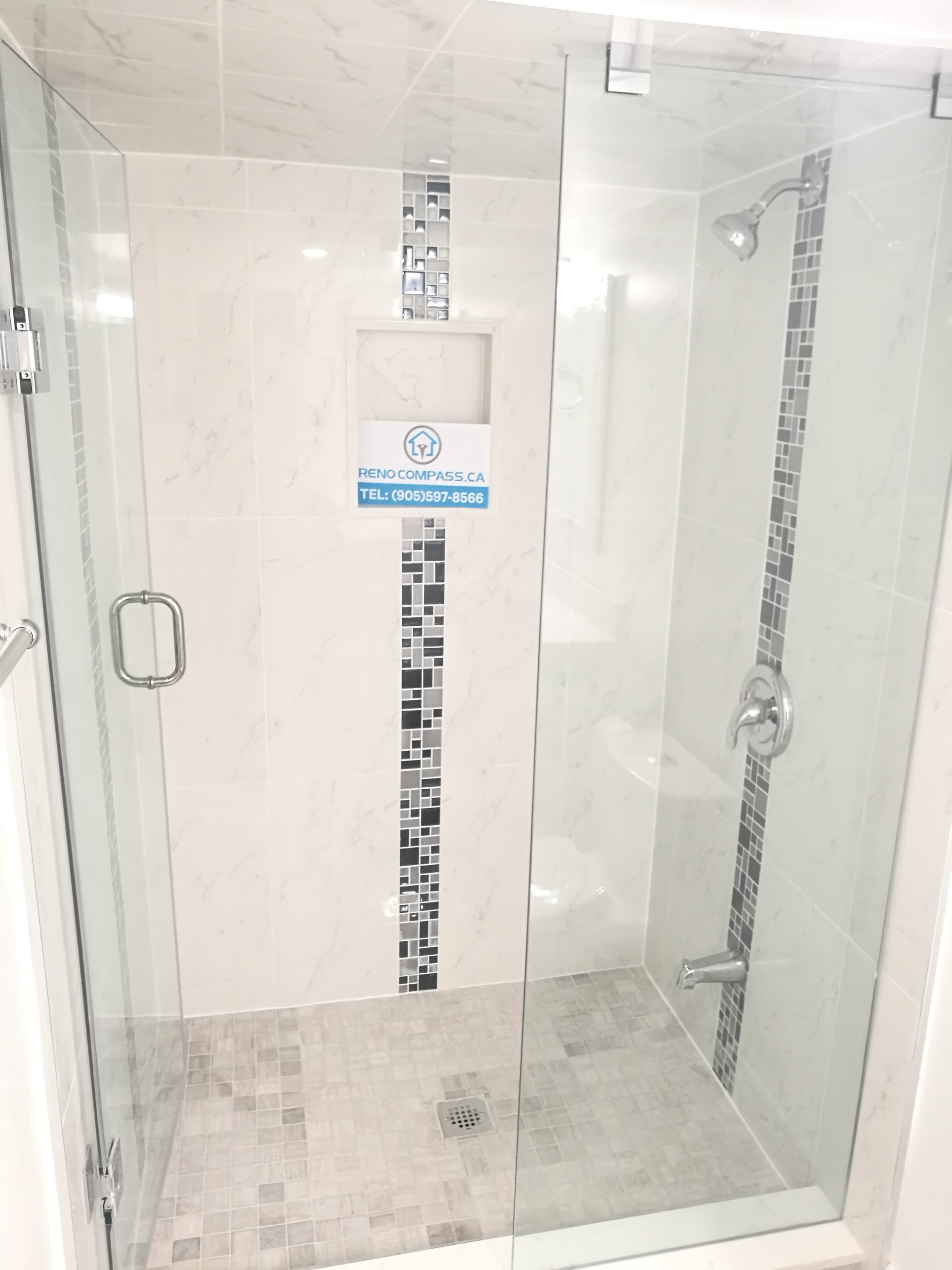 Bathroom renovation project in Pickering featuring a frameless glass shower enclosure, built-in wall niche, mosaic tile accent strip, and modern chrome fixtures. The clean tile layout and clear glass design create a bright, open shower space, showcasing professional workmanship by a Toronto renovation company.