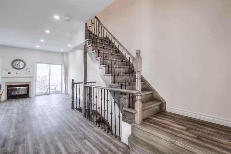 This Thornhill interior renovation highlights a beautifully upgraded staircase with modern iron railings, refinished wood steps, and new wood-style flooring throughout the main floor. The open-concept layout is enhanced with fresh paint, recessed lighting, and improved finishing details to create a bright and contemporary living space. Completed by a professional Toronto renovation team, this project showcases quality craftsmanship and modern interior transformation for a stylish and functional home.