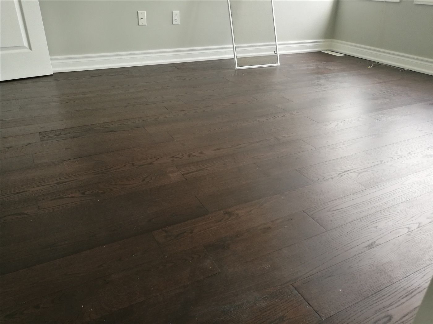 This image highlights dark hardwood flooring installed as part of a Markham interior renovation. The clean plank alignment, smooth finish, and natural light from surrounding windows reflect the quality workmanship of a professional Toronto Renovation Company focused on durability and interior consistency.