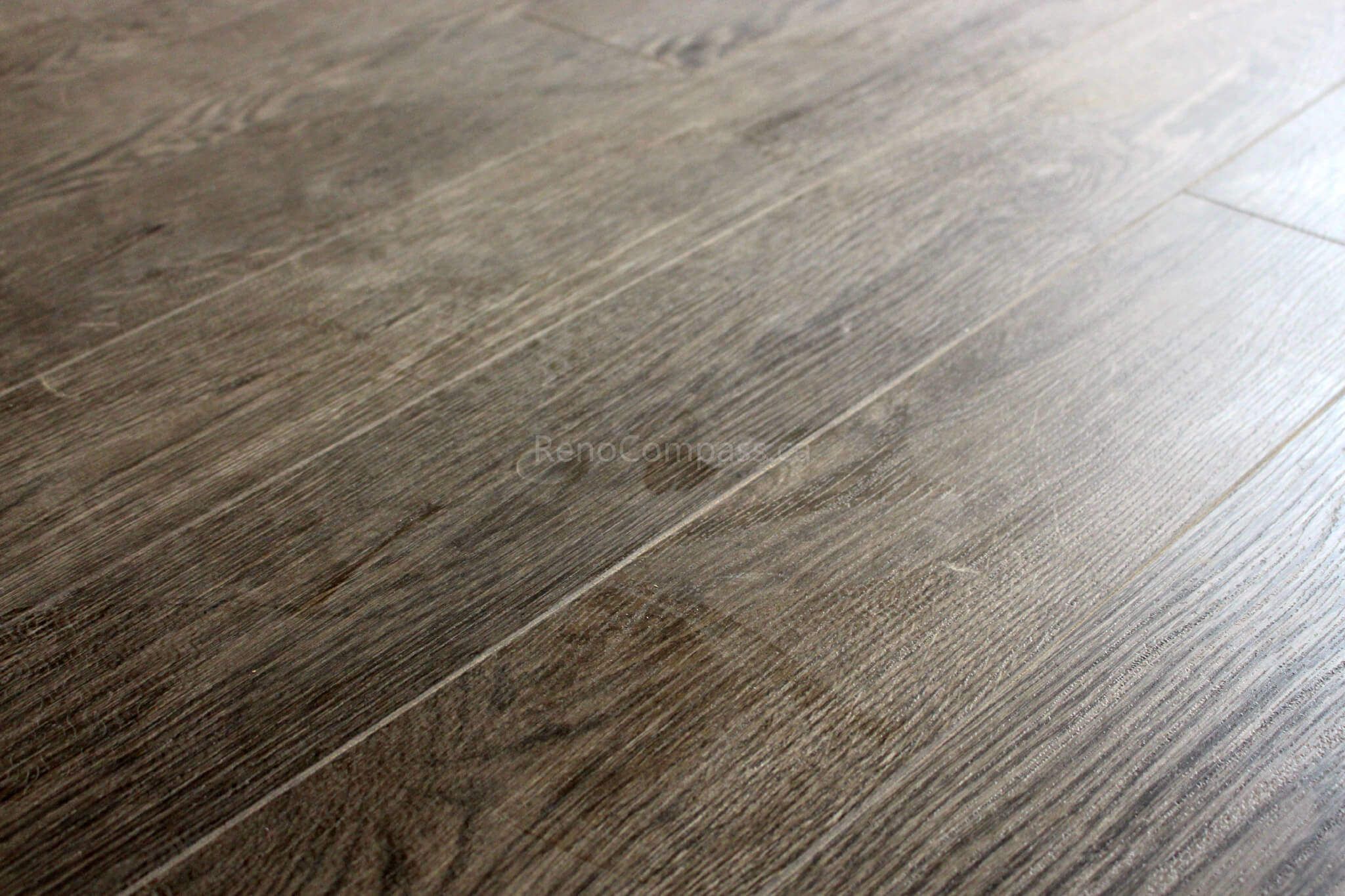 Newly installed dark wood-look luxury vinyl flooring with crisp white baseboards, enhancing the elegance of this Mississauga home renovation. The modern flooring finish blends durability and style, ideal for contemporary interiors.
