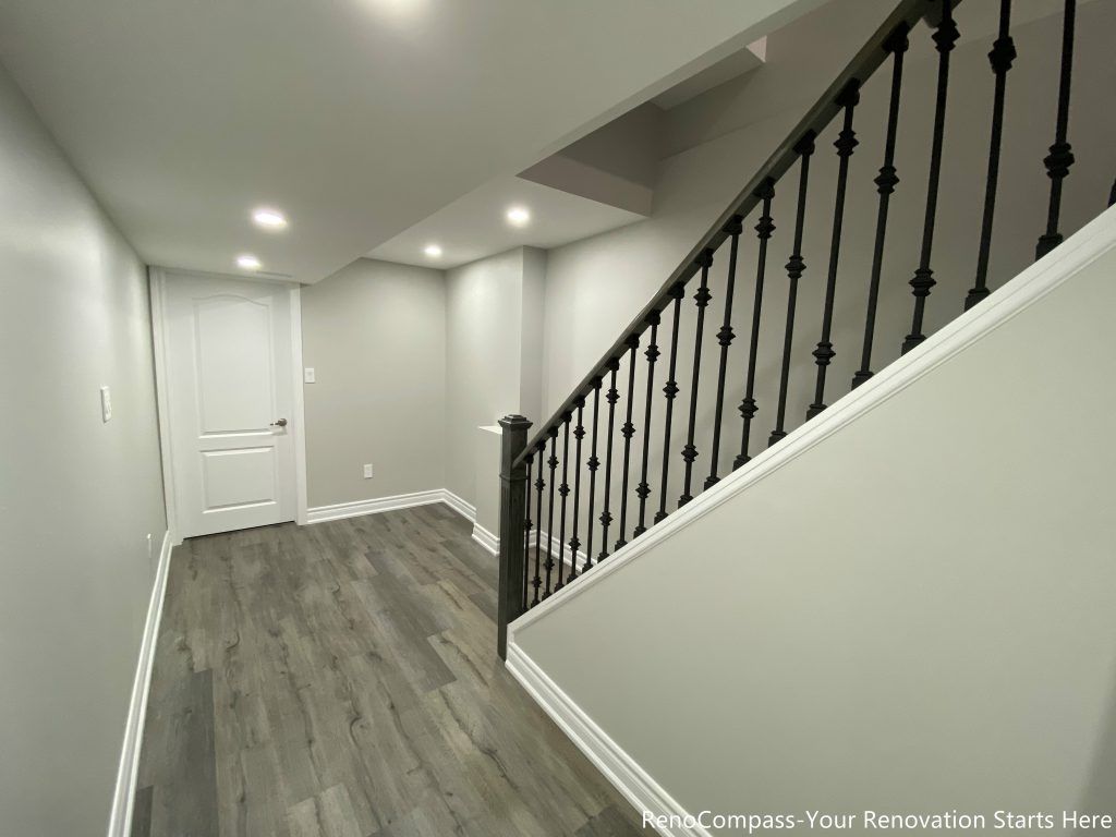 This Oakville basement renovation features a clean and modern staircase landing with upgraded flooring, fresh wall finishes, and recessed pot lighting that brightens the entire lower level. The redesigned layout improves flow between rooms while maintaining a simple and contemporary aesthetic. Completed by a professional Toronto renovation company, this basement upgrade enhances functionality, lighting, and durability, creating a polished and comfortable finished space that adds long-term value to the home.