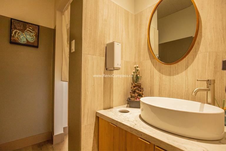 This Richmond Hill Chinese restaurant renovation by Toronto renovation company Reno Compass Inc. includes a modern commercial washroom designed for both functionality and aesthetic appeal. The upgraded space features wood-texture wall finishes, custom vanity cabinetry, a stone countertop, contemporary vessel sink, and warm ambient lighting. Thoughtful material selection and clean design details create a comfortable and hygienic restroom environment, enhancing the overall customer experience and supporting daily restaurant operations with durable, easy-to-maintain finishes.