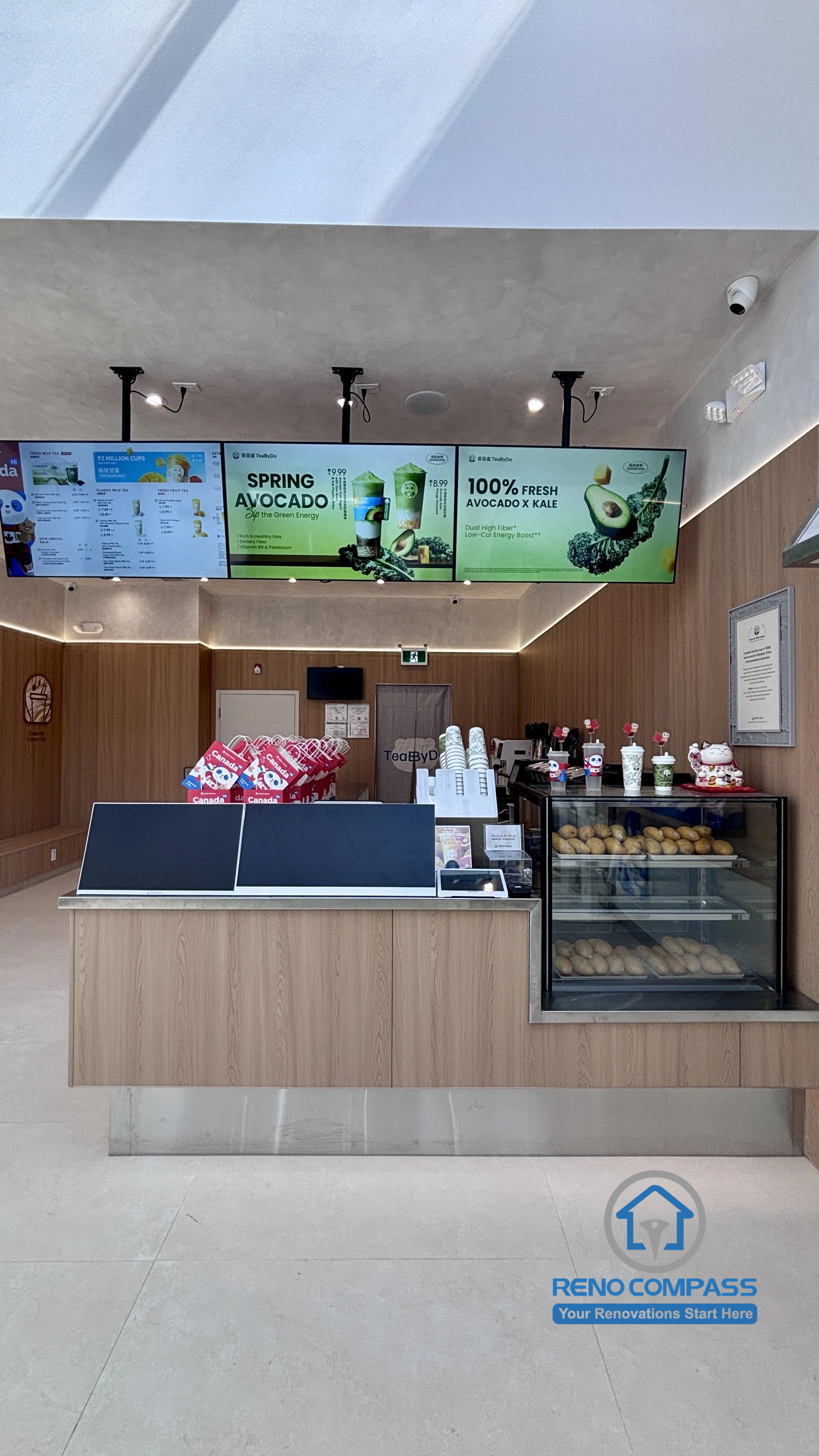 Completed TEABYDO bubble tea shop renovation in Richmond Hill featuring a modern front service counter, digital menu boards, beverage display fridge, custom commercial millwork, integrated ceiling lighting, and minimalist café interior design. Commercial renovation project completed by Reno Compass serving Richmond Hill, Toronto, and the GTA.