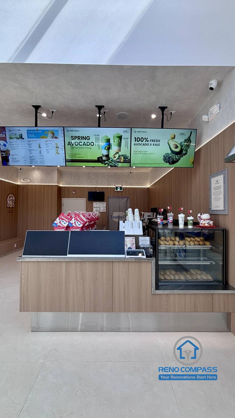 Completed TEABYDO bubble tea shop renovation in Richmond Hill featuring a modern front service counter, digital menu boards, beverage display fridge, custom commercial millwork, integrated ceiling lighting, and minimalist café interior design. Commercial renovation project completed by Reno Compass serving Richmond Hill, Toronto, and the GTA.