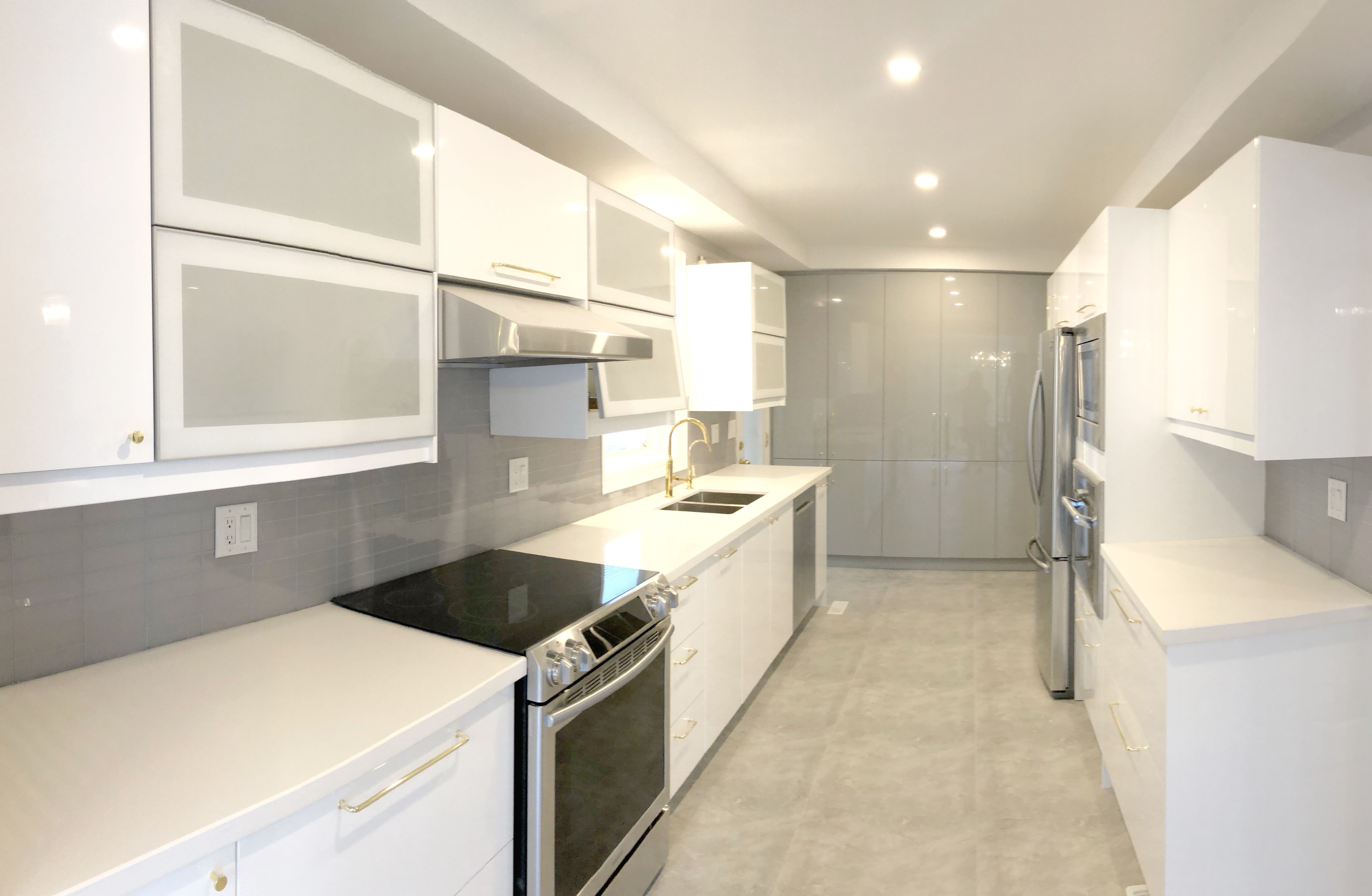 This Etobicoke kitchen renovation features a sleek modern layout with custom white cabinetry, quartz countertops, and stainless steel appliances for a clean and functional cooking space. The galley-style design maximizes efficiency, while under-cabinet lighting and recessed ceiling lights enhance brightness throughout the kitchen. A neutral backsplash and durable flooring complete the timeless look. Designed and completed by Reno Compass Inc., this kitchen upgrade focuses on practicality, storage optimization, and modern everyday living.