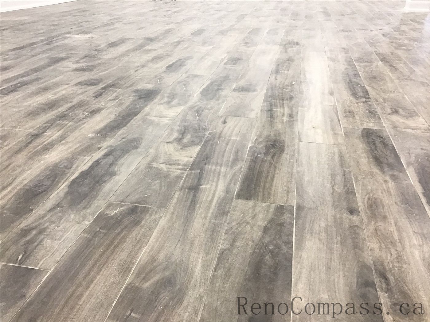 Close-up of premium wood-look vinyl plank flooring installed in a Richmond Hill basement renovation. This durable, waterproof flooring solution offers a modern grey-brown tone with natural texture, making it ideal for high-traffic basement living spaces. Professionally installed as part of a high-quality basement renovation by a trusted Toronto Renovation Company.