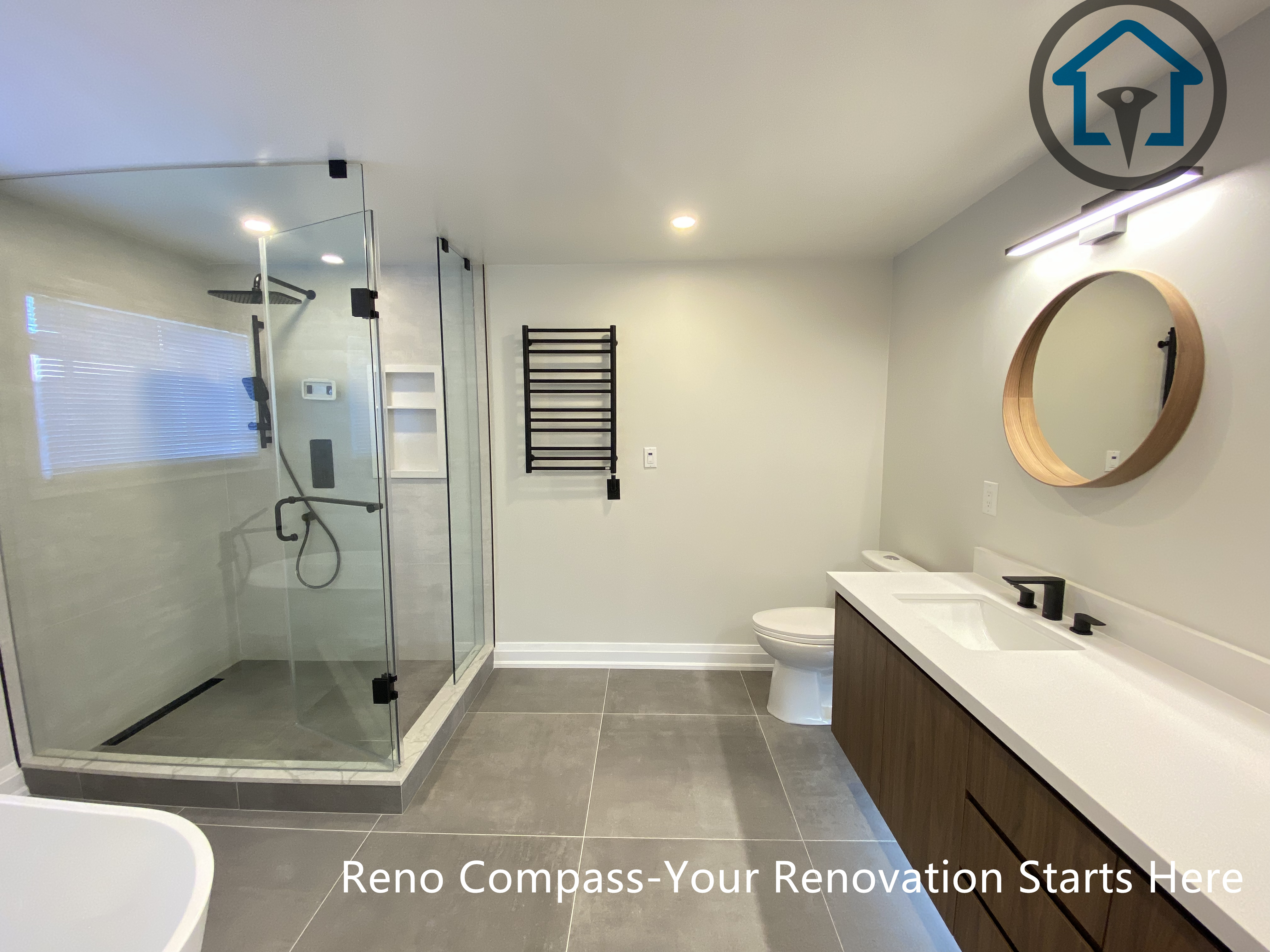 Contemporary bathroom renovation in Markham showcasing a custom double sink vanity, integrated LED mirror lighting, matte black faucets, and large-format floor tiles. The design balances clean lines, warm wood tones, and practical storage, completed by a trusted Toronto renovation company.