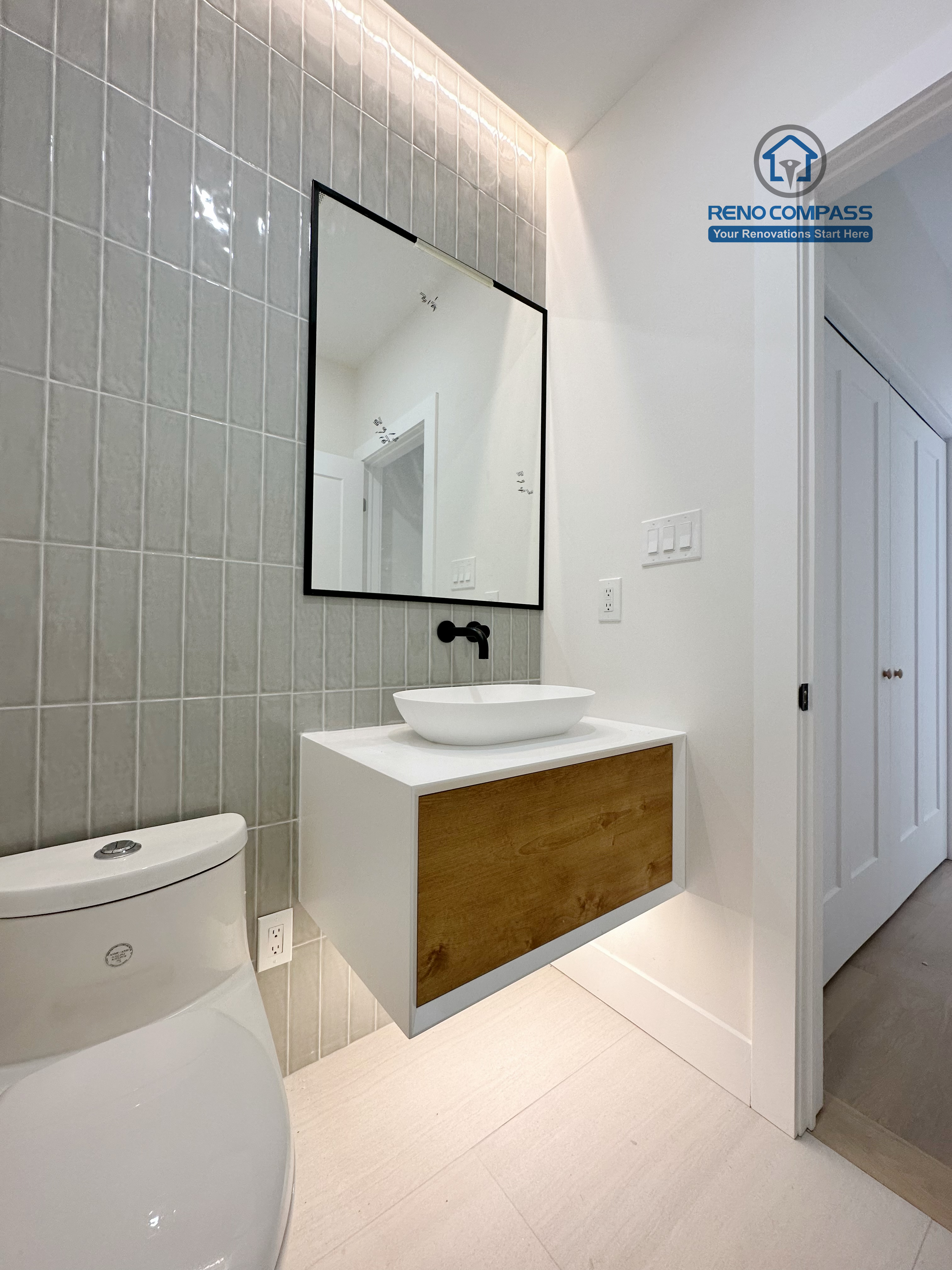 Contemporary bathroom renovation in Richmond Hill featuring a floating wood-accent vanity, modern vessel sink, matte black fixtures, and vertical tile backsplash for a clean and stylish bathroom design.