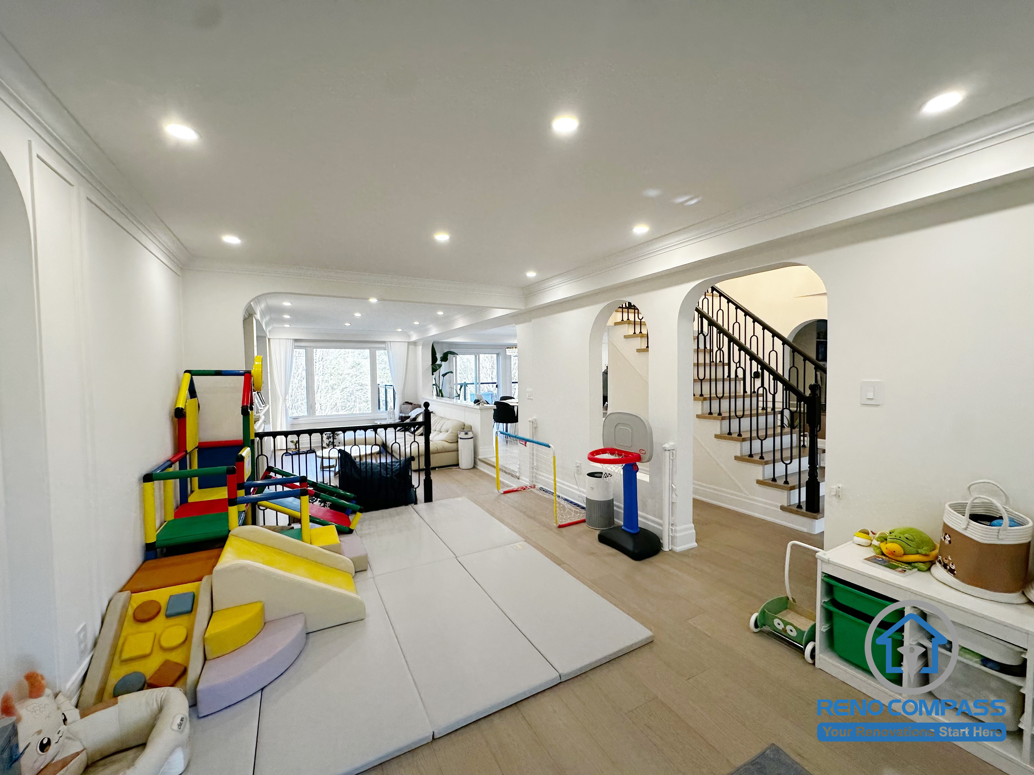 This Markham interior renovation was designed with everyday family life in mind, transforming the main living area into a flexible, child-friendly space that supports both play and relaxation. The open layout allows parents to maintain clear sightlines across the room while creating a safe and comfortable area for children’s activities.

Arched openings and consistent ceiling details help connect different zones of the home, while layered recessed lighting ensures the space remains bright and functional throughout the day. The combination of soft play areas and durable flooring makes the room adaptable as family needs evolve over time.

By balancing openness, safety, and long-term usability, this interior renovation creates a welcoming environment that works seamlessly for modern family living in Markham.