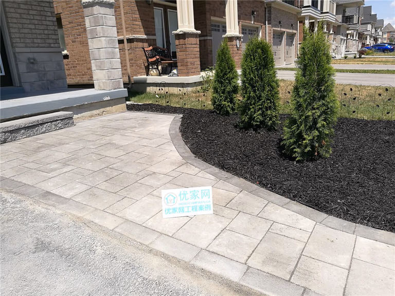 This Stouffville landscaping renovation features a newly installed interlock walkway and refreshed front yard garden bed with evergreen planting and decorative mulch. The curved hardscape design creates a smooth transition from driveway to porch while improving curb appeal and outdoor usability. Completed as part of a professional Toronto landscaping renovation project, the upgrade enhances both the visual balance and long-term durability of this modern residential front entrance.