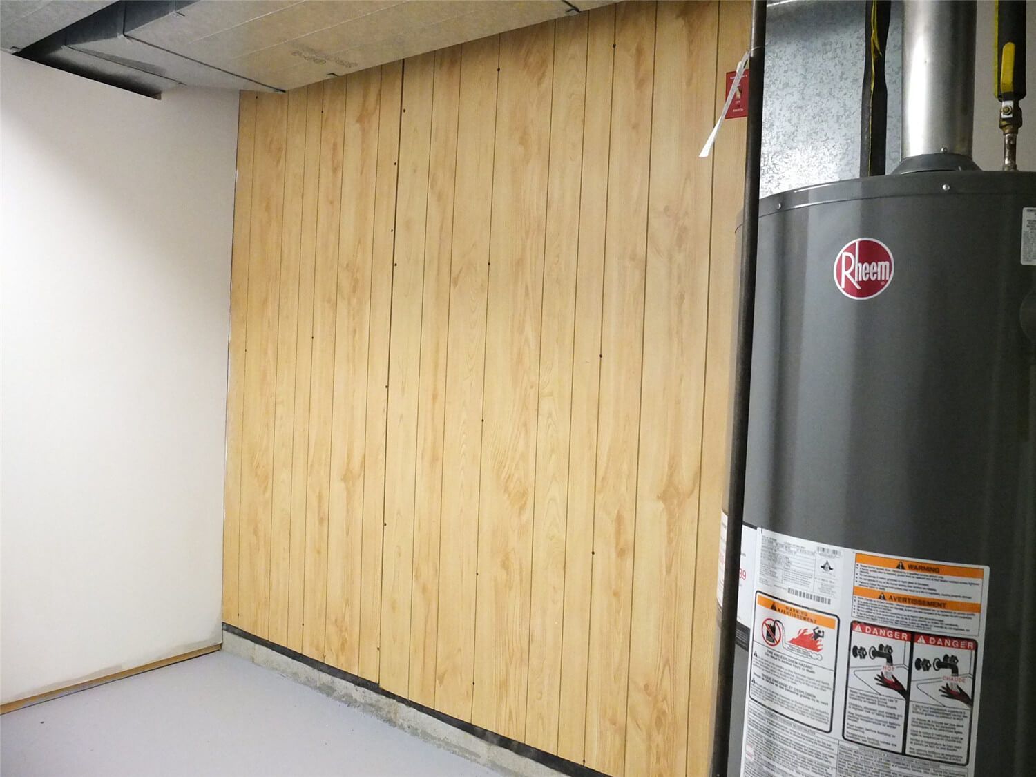 This Markham basement renovation includes improvements to the utility and mechanical room area. The project features newly finished wall panels, organized mechanical space, and protected installation around the water heater and ductwork. The clean wall finishing and structured layout help create a safer and more organized basement utility area while maintaining easy access for maintenance.