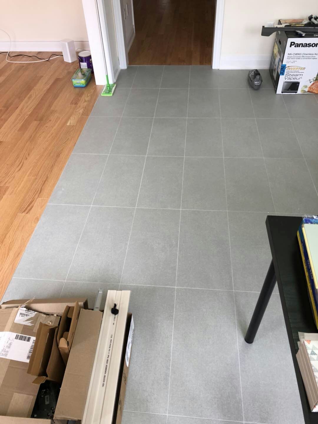 Light grey tile flooring installation in a Toronto interior renovation project. Even tile spacing, clean grout lines, and precise workmanship ensure a seamless transition between living areas, creating a modern, bright, and low-maintenance interior floor finish.