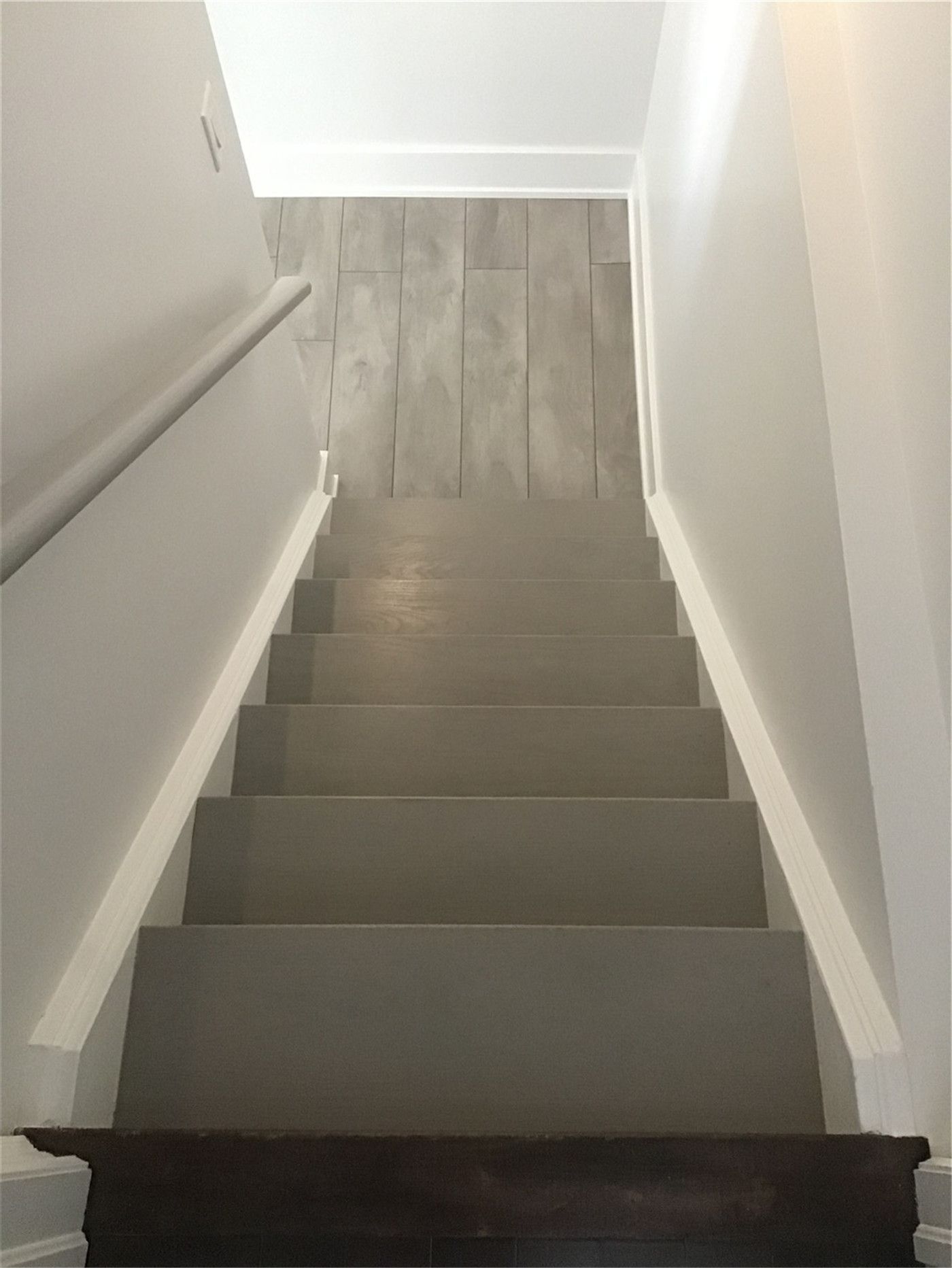 This Markham full home renovation features a clean and modern staircase with updated steps, smooth white railings, and a seamless transition to durable vinyl plank flooring. The neutral color palette enhances brightness and continuity between levels, creating a cohesive and functional layout. Completed by a professional Toronto Renovation Company, this design emphasizes both safety and modern simplicity.