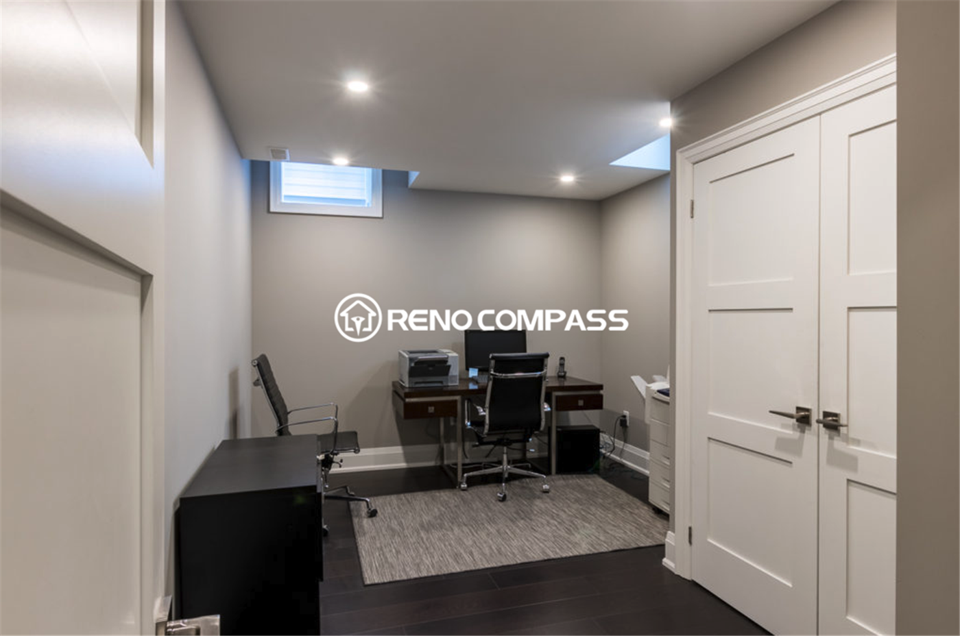 Modern basement home office renovation in Toronto featuring a functional workspace layout, recessed ceiling lighting, large storage cabinet, and dark hardwood flooring. This professionally finished basement office provides a quiet and comfortable work environment, completed by a trusted Toronto renovation company, Reno Compass Inc.
